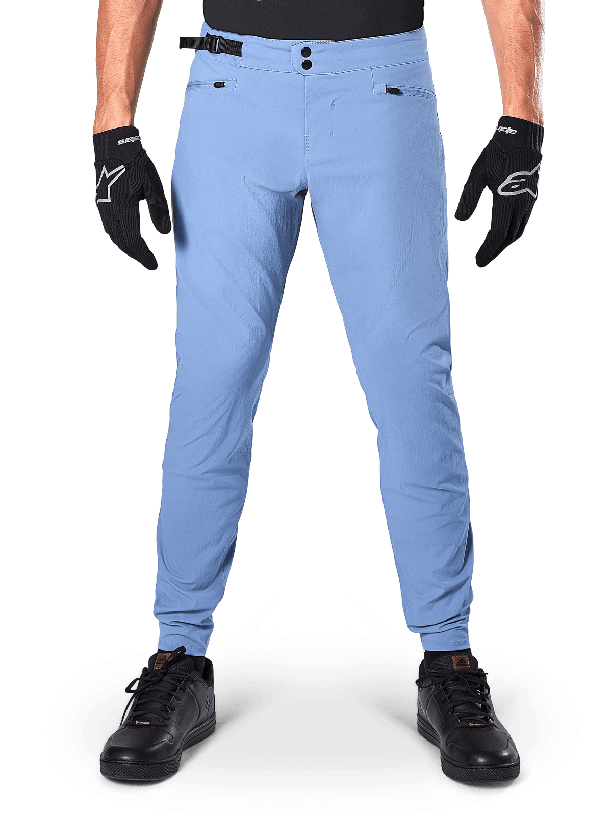 Alpinestars A-Dura Pants, spodnie MTB, Infinity Blue, jasnoniebieskie spodnie rowerowe górskie z podwójnym zapięciem na zatrzaski i kieszeniami na zamek, noszone z czarnymi rękawiczkami i czarnymi butami, regularny krój z elastycznymi mankietami