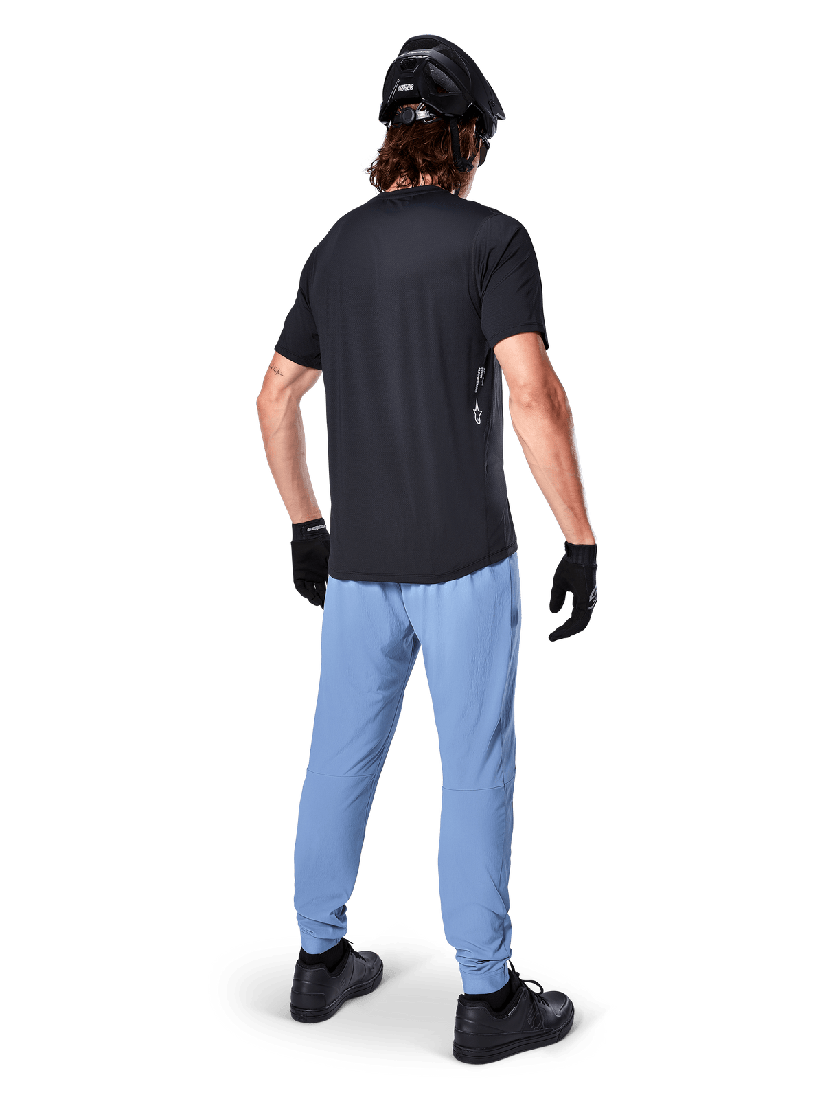 Spodnie Alpinestars A-Dura, spodnie MTB, Infinity Blue, widok z tyłu na modelu w czarnym t-shircie i czarnym kasku rowerowym, wykonane z wytrzymałej tkaniny 2-way stretch z elastycznymi mankietami, odzież wyczynowa do kolarstwa górskiego