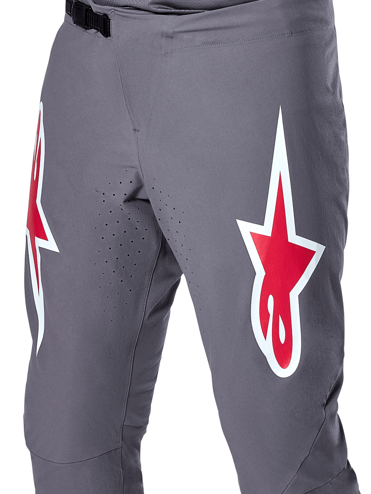 Alpinestars A-Supra Race Pants, spodnie rowerowe MTB, ciemnoszare z czerwonymi i białymi logo, zbliżenie na laserową perforację wentylacyjną na wewnętrznej stronie ud i czarne zapięcie zapadkowe w pasie.