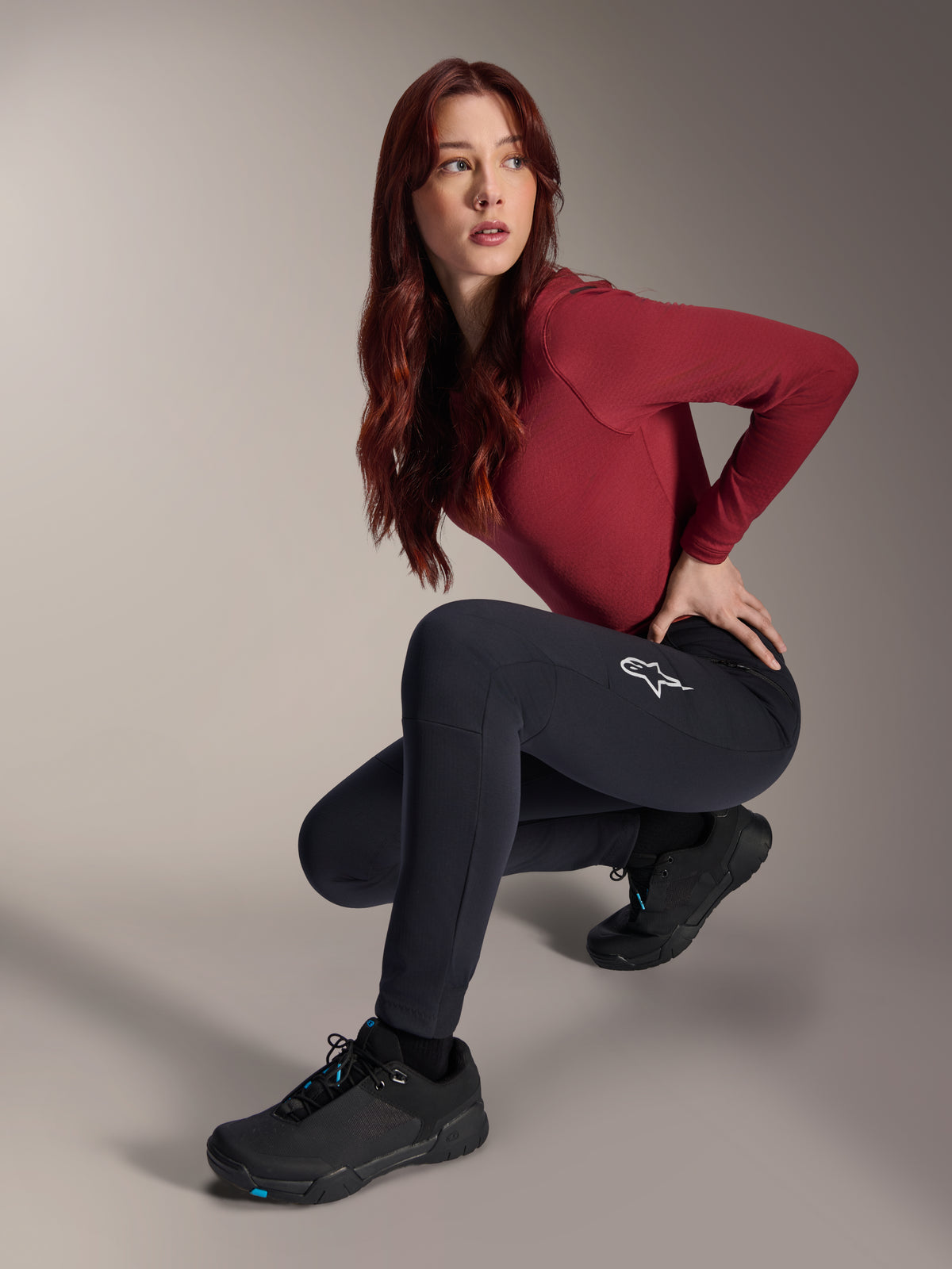 Alpinestars Stella A-Dura Thermal Pants, Women's MTB Pants, Black, worn by a model in a crouching pose with a maroon long-sleeve top and black cycling shoes, featuring a white star logo on the thigh, durable and warm construction for cold-weather off-road riding