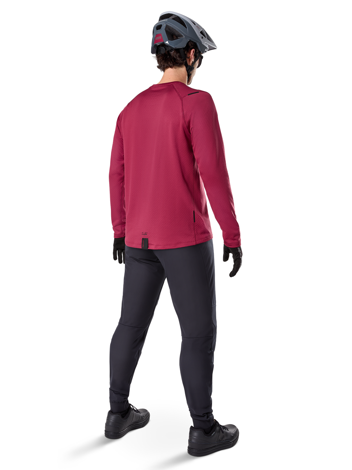 Alpinestars A-Dura Thermal Jersey, bordowa koszulka rowerowa z długim rękawem, widok z tyłu, zestawiona z czarnymi spodniami MTB i szarym kaskiem, przedłużony tył zapewniający osłonę, odzież rowerowa na chłodne dni