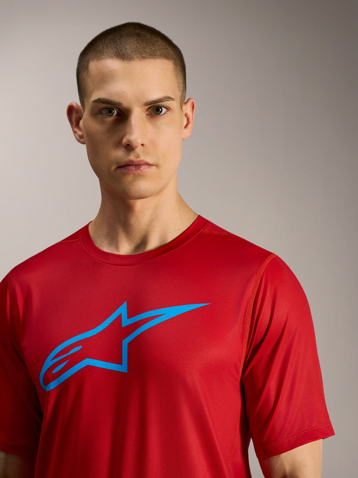 Czerwona koszulka Alpinestars A-Dura Ride z krótkim rękawem, niebieskie logo na piersi, techniczna odzież MTB.