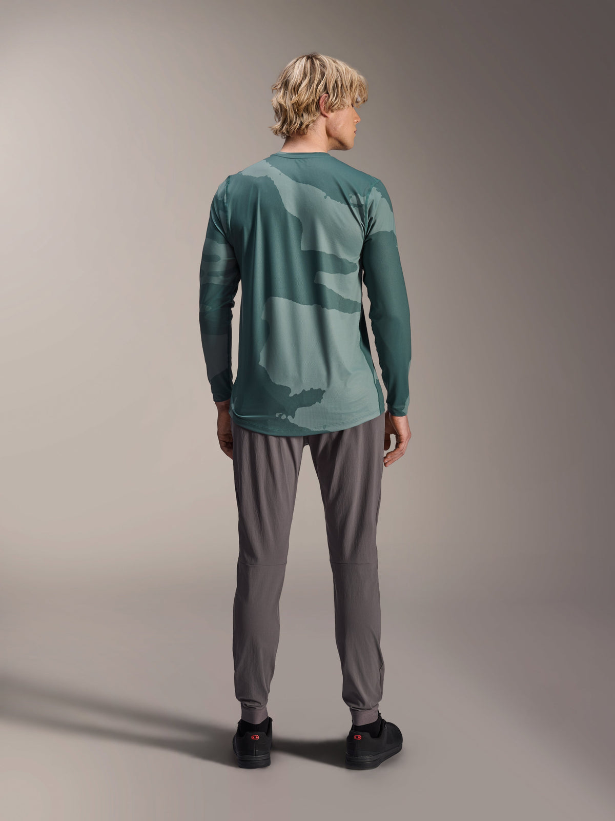 Alpinestars A-Dura Hollow Camo Jersey - Long Sleeve, koszulka z długim rękawem, zielony wzór kamuflażu Silver Pine Camo, model widoczny od tyłu w szarych spodniach technicznych, wyczynowa odzież do kolarstwa górskiego