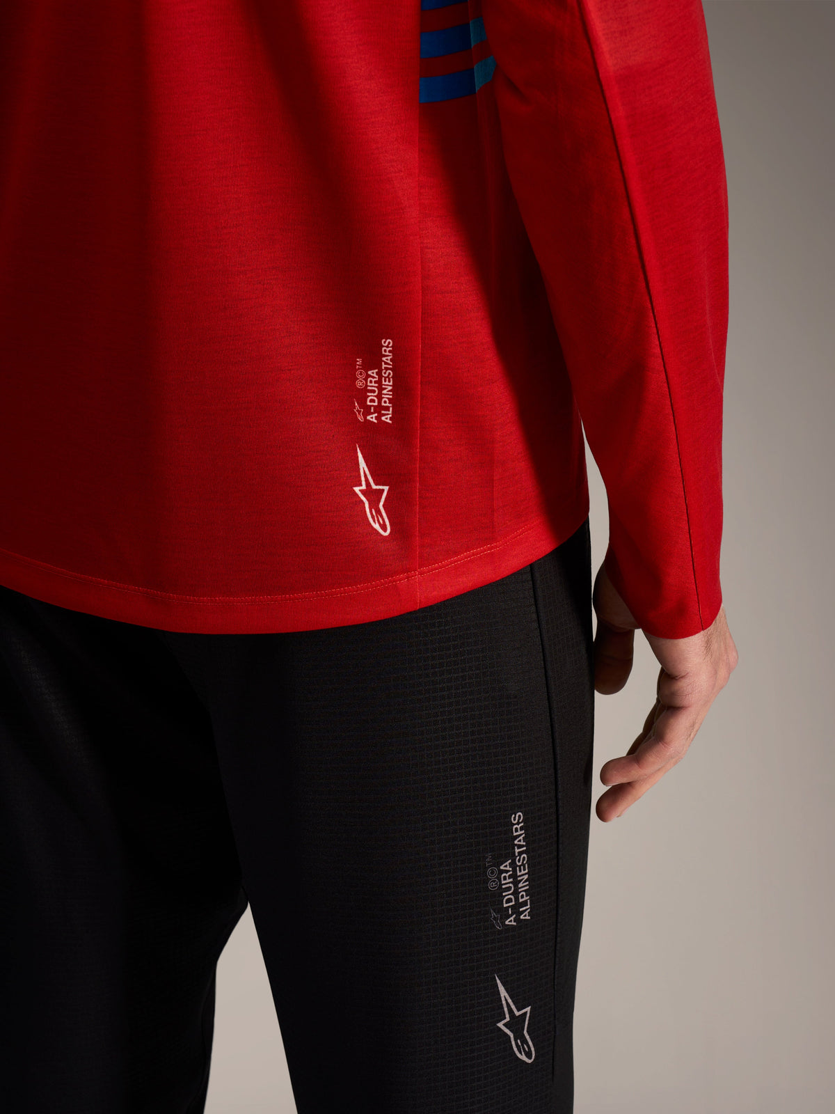 Czerwona koszulka A-Dura Elite 2.0 i czarne spodnie MTB z logo Alpinestars, techniczny materiał.
