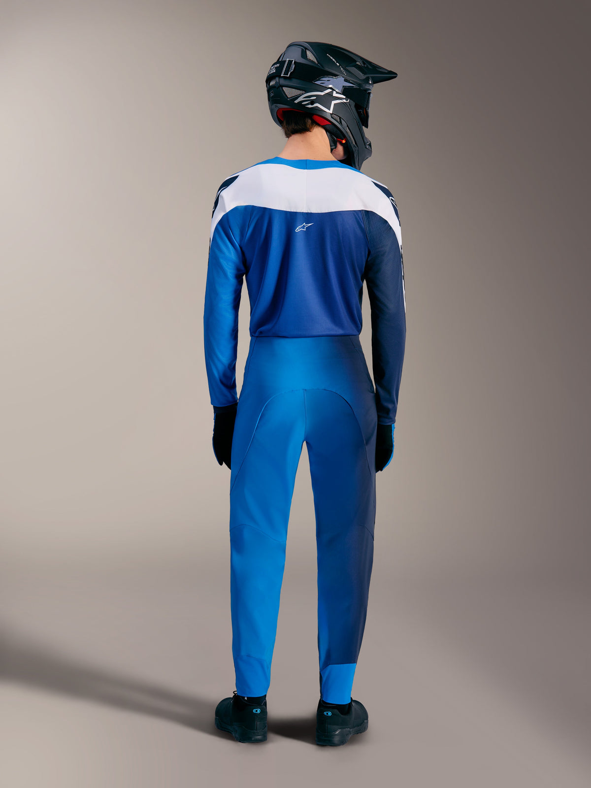 Zestaw Alpinestars A-Supra Elite MTB Faded Bright Blue, widok z tyłu na koszulkę z gradientem i spodnie z białymi panelami.