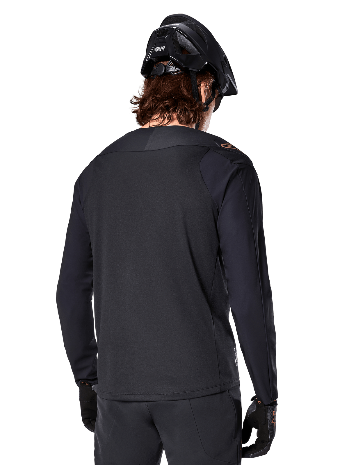 Alpinestars A-Aria Polartec Switch Jersey - Long Sleeve, czarna, widok z tyłu, noszona z czarnym kaskiem MTB i rękawicami, z przedłużonym tyłem zaprojektowanym dla lepszej wydajności w terenie