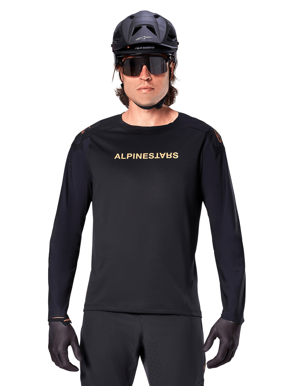 Alpinestars A-Aria Polartec Switch Long Sleeve Jersey, czarna, złote logo Alpinestars na piersi, noszona z czarnym kaskiem MTB, ciemnymi okularami i czarnymi rękawiczkami, profesjonalna odzież na rower górski