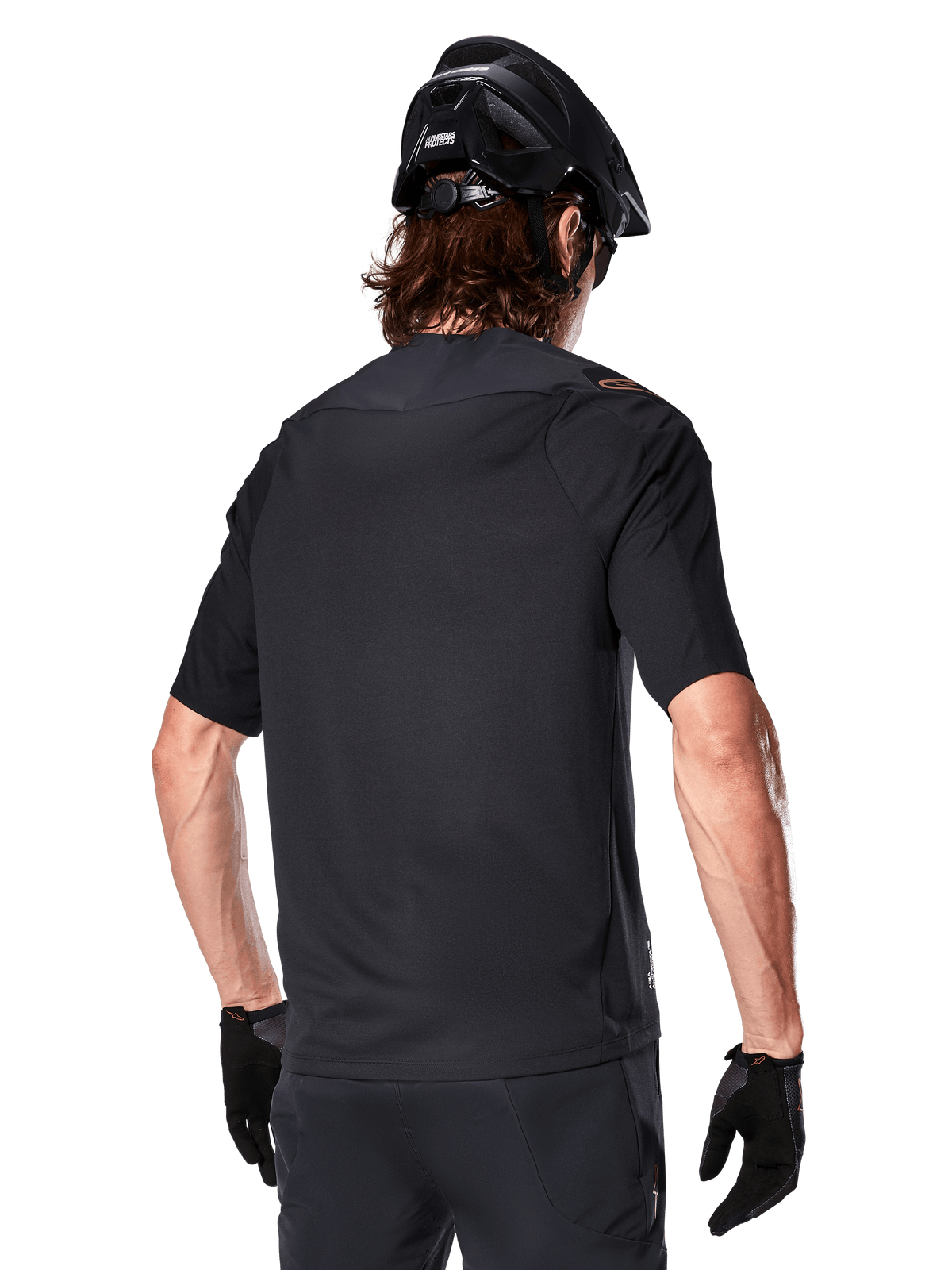 Koszulka Alpinestars A-Aria Polartec Switch z krótkim rękawem, czarna, widok z tyłu na rowerzystę w czarnym kasku MTB, pasujących czarnych szortach i rękawiczkach, odzież wyczynowa do jazdy na rowerze górskim