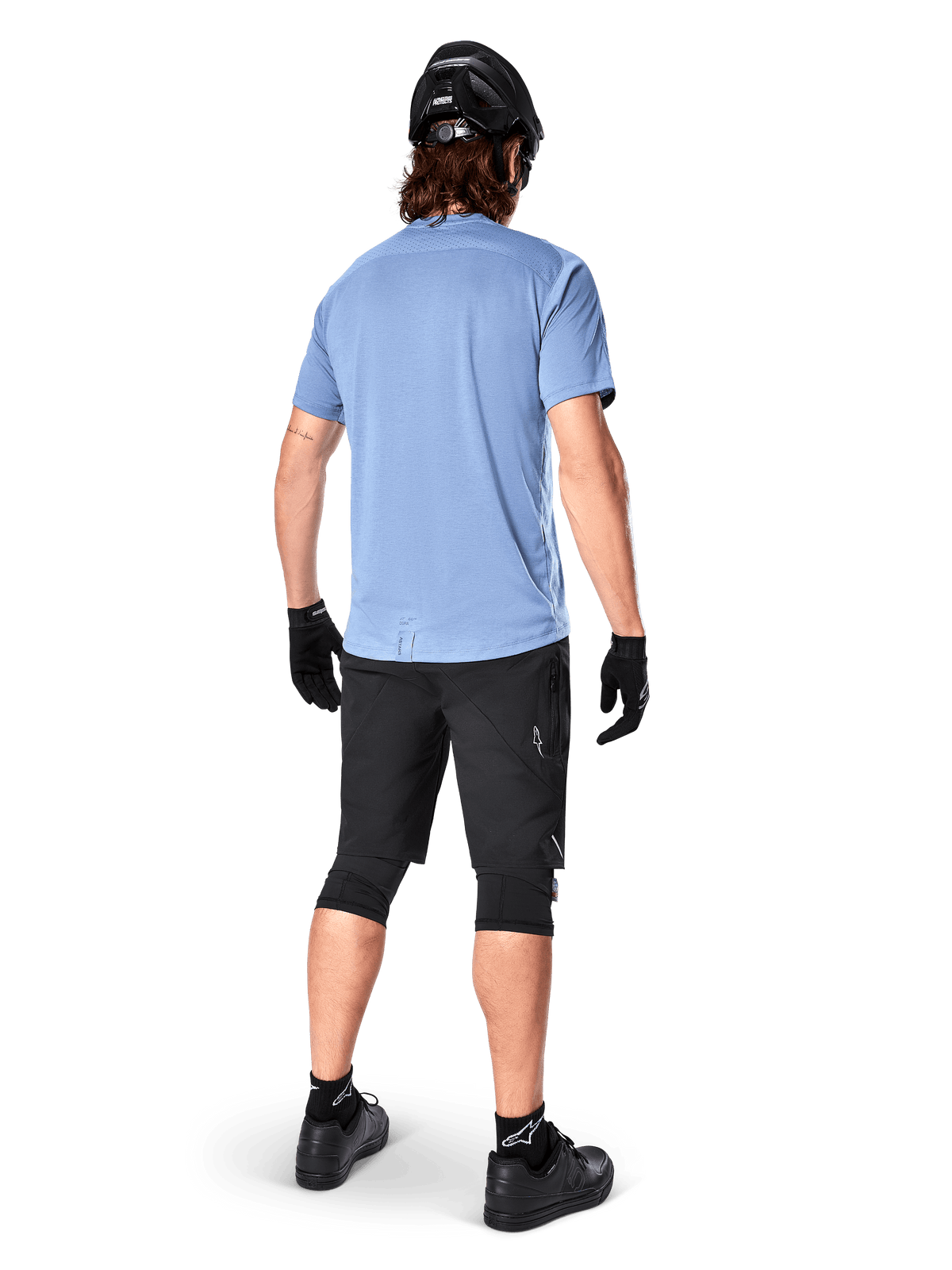 Alpinestars A-Dura Dri Astar Short Sleeve Jersey, Infinity Blue, rear view, paired with black mountain bike shorts and helmet, technical cycling apparel with moisture-wicking fabric and drop tail