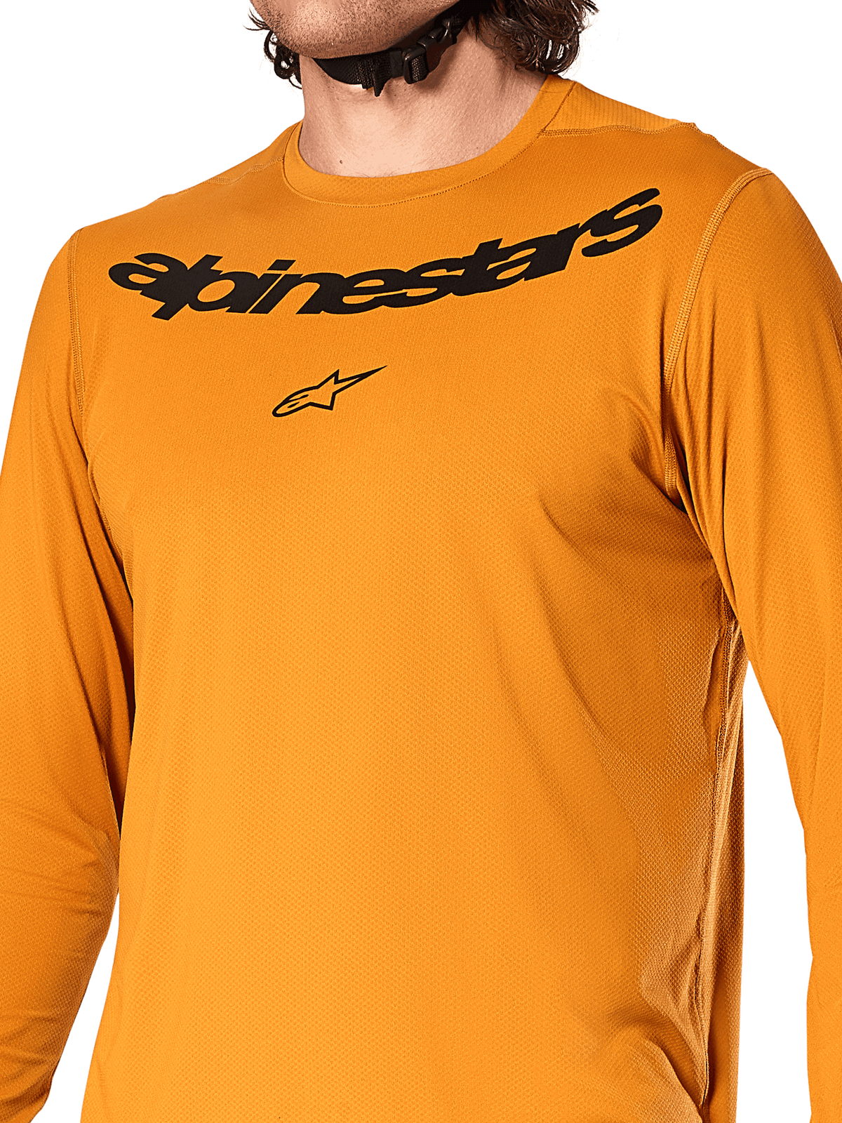 Alpinestars A-Dura Rocker Long Sleeve Jersey, kolor ciemnozłoty, zbliżenie na klatkę piersiową z czarnym napisem Alpinestars i logo gwiazdy, teksturowany dżakardowy materiał odprowadzający wilgoć, techniczna odzież rowerowa MTB