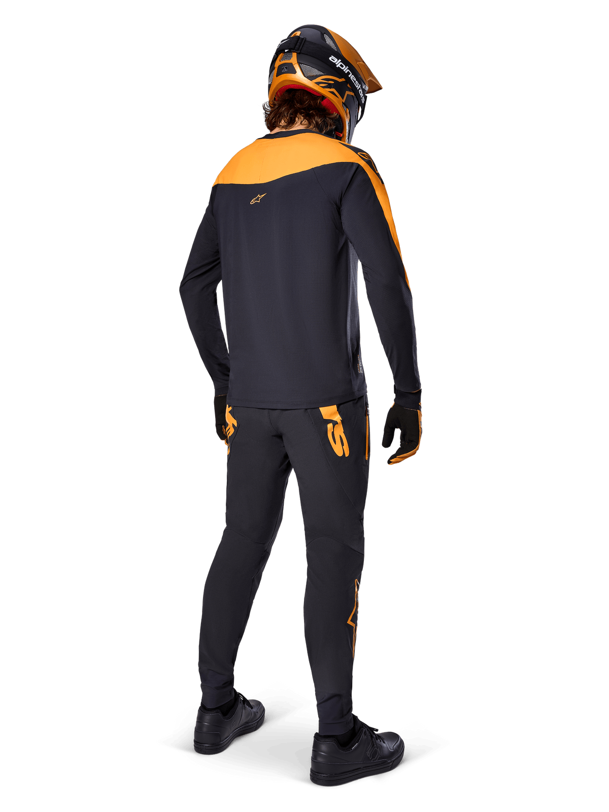 Koszulka A-Supra Race Jersey z długim rękawem, czarno-pomarańczowa, widok z tyłu na rowerzystę w pasujących spodniach MTB, pomarańczowo-czarnym kasku i rękawicach, odzież wyczynowa do wyścigów MTB