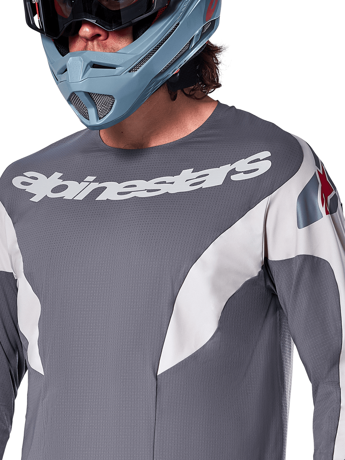 Alpinestars A-Supra Race Jersey - Long Sleeve, koszulka MTB, ciemnoszara z białą grafiką wyścigową i białym logo Alpinestars, noszona z jasnoniebieskim kaskiem full-face i goglami, mikroperforowany materiał dla wydajności off-road