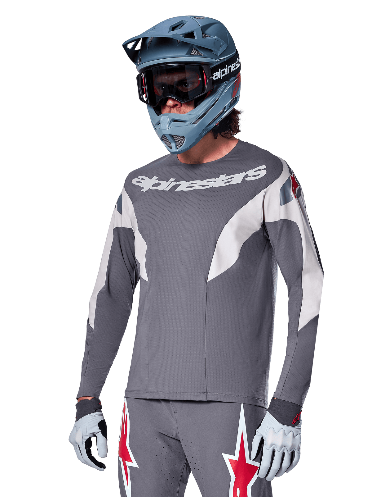 Alpinestars A-Supra Race Jersey - Long Sleeve, ciemnoszara koszulka z długim rękawem, białe i czerwone akcenty, grafika w stylu wyścigowym, noszona z pasującymi szarymi spodniami, niebieskim kaskiem full-face i białymi rękawicami, profesjonalny sprzęt do MTB i downhillu