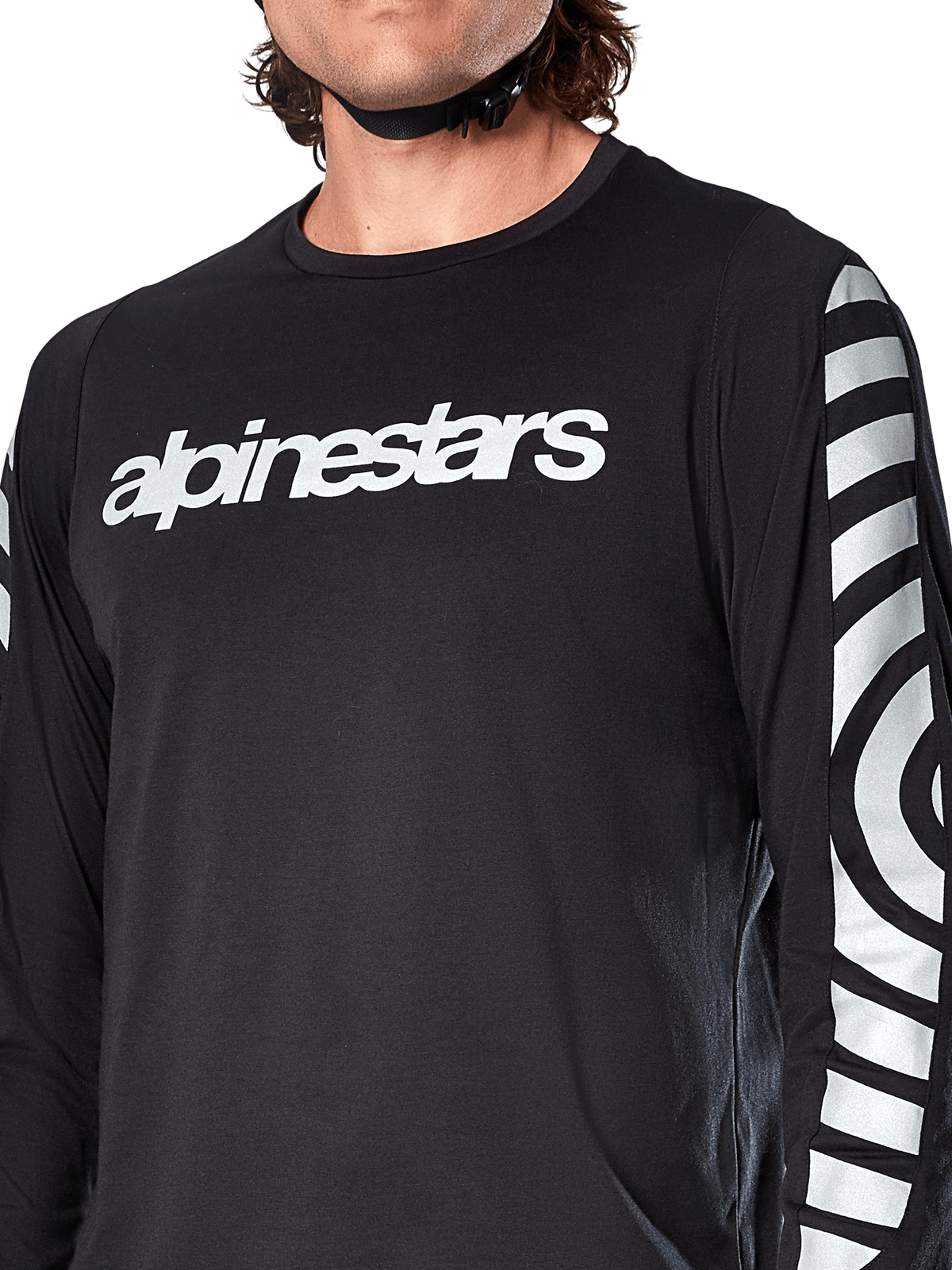 Alpinestars A-Dura Dri Oscar Long Sleeve Jersey, Black Reflective, close-up view showing white alpinestars logo on the chest and reflective circular graphics on the sleeves, technical cycling apparel for mountain biking
