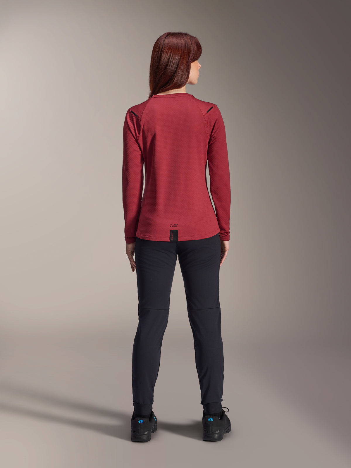 Alpinestars Stella A-Dura Thermal Pants, Women's Mountain Bike Pants, Black, worn with a burgundy long-sleeved thermal jersey, back view showing the technical fit and construction for cold-weather cycling.