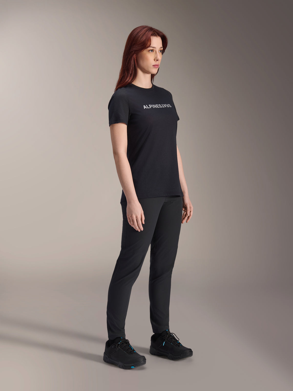 Alpinestars Stella A-Dura Dri Switch Jersey, rowerowa koszulka z krótkim rękawem, czarna z białym logo Alpinestars, prezentowana przez modelkę w czarnych spodniach i butach, wszechstronny sprzęt do kolarstwa górskiego
