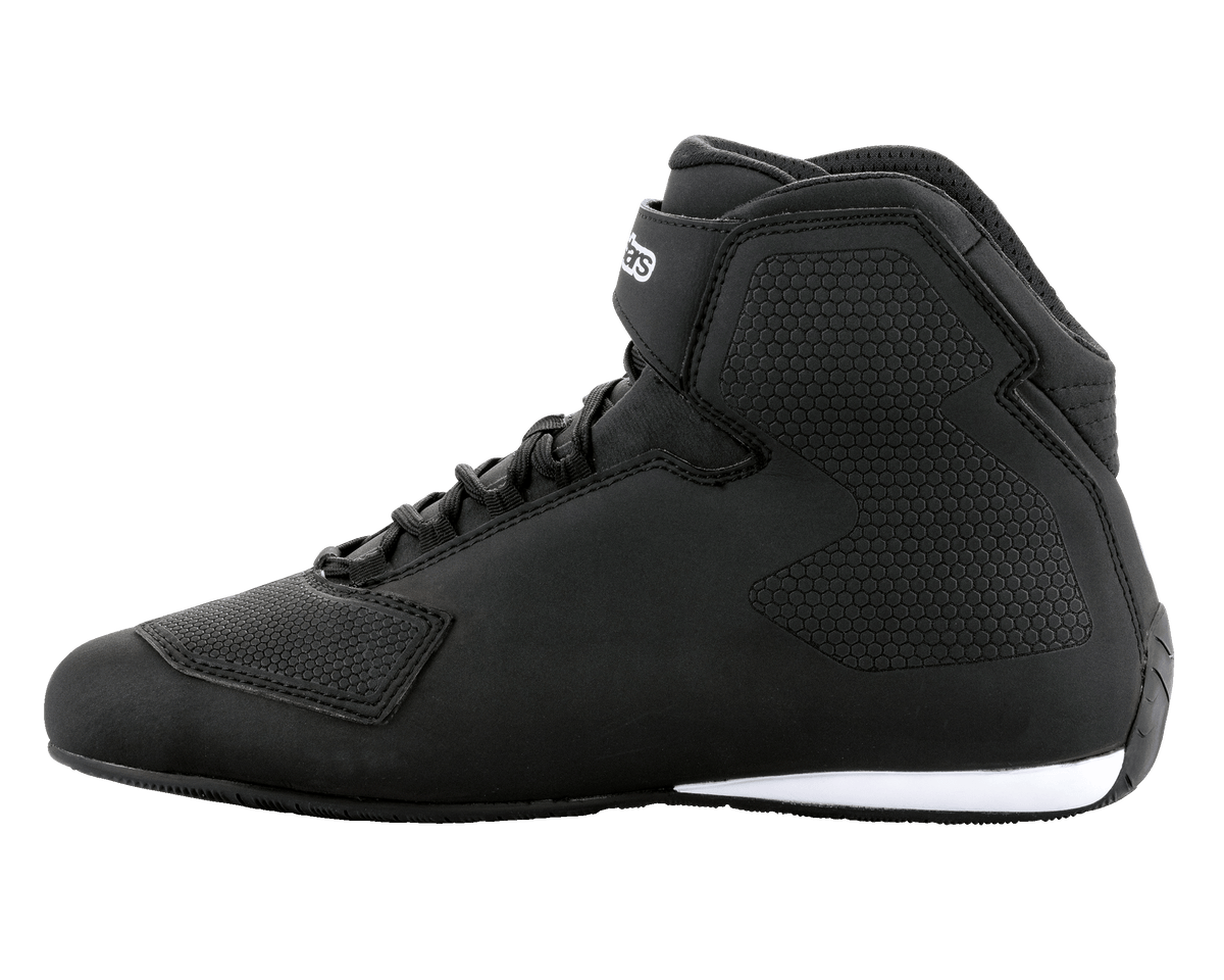 Buty Alpinestars Sektor, czarno-białe buty motocyklowe, wysoki profil, system szybkiego sznurowania z paskiem na kostce, teksturowana konstrukcja z mikrofibry, białe detale podeszwy na pięcie, eleganckie obuwie ochronne do jazdy szosowej