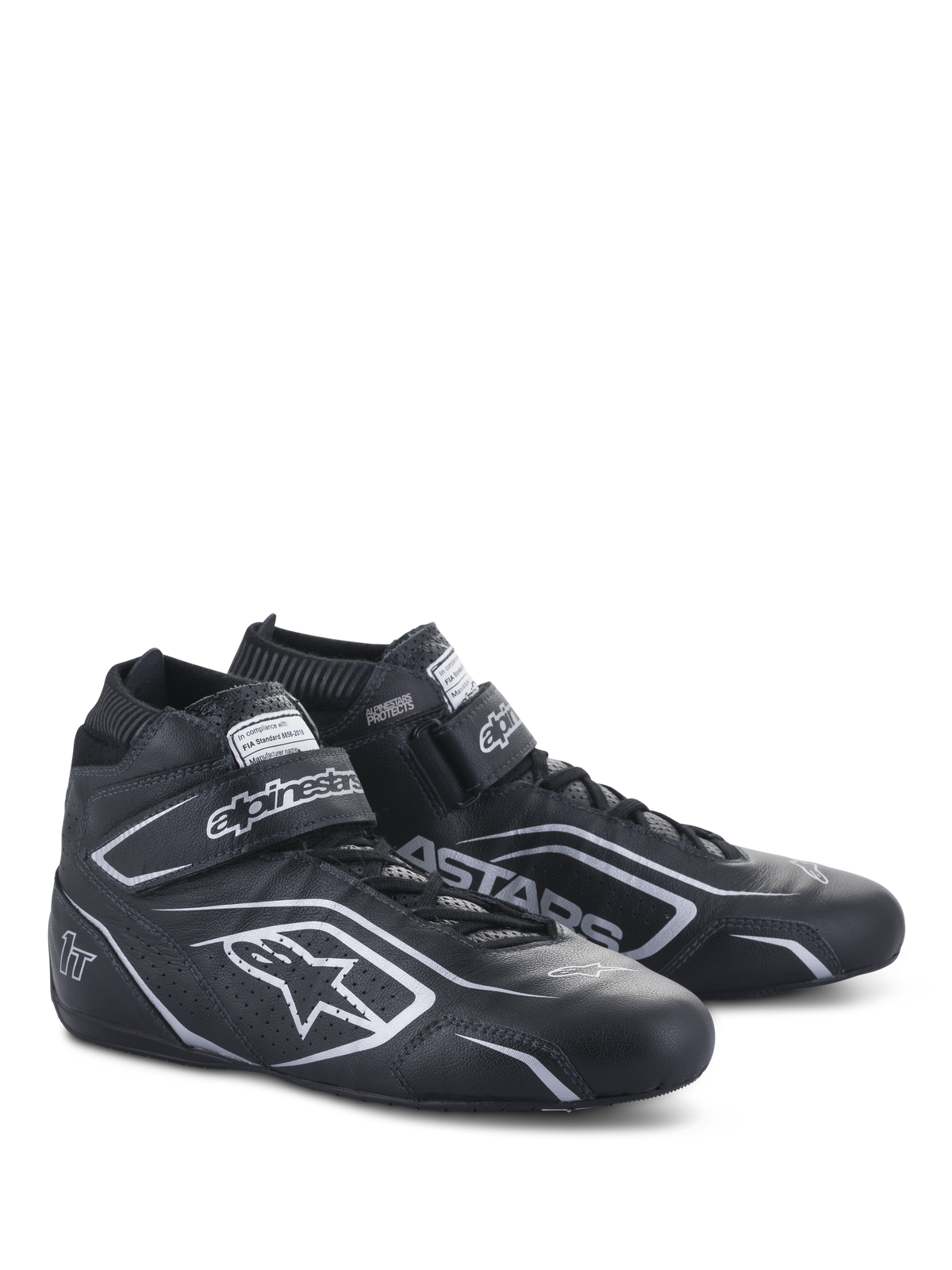 Buty Alpinestars Tech-1 T V3 FIA, buty do wyścigów samochodowych, czarno-srebrne, wykonane ze skóry bydlęcej ze srebrnym logo i oznaczeniami Alpinestars, widok z boku pod kątem z zapięciem na rzep i sznurowadłami