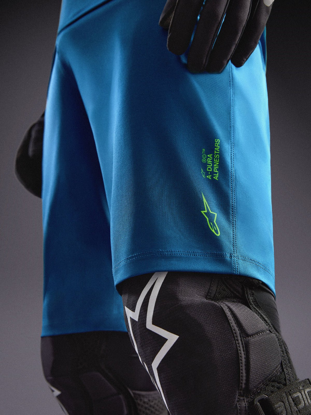 Szorty Alpinestars A-Dura Ride w kolorze niebiesko-zielonym z limonkowym logo i ochraniaczami kolan do MTB.