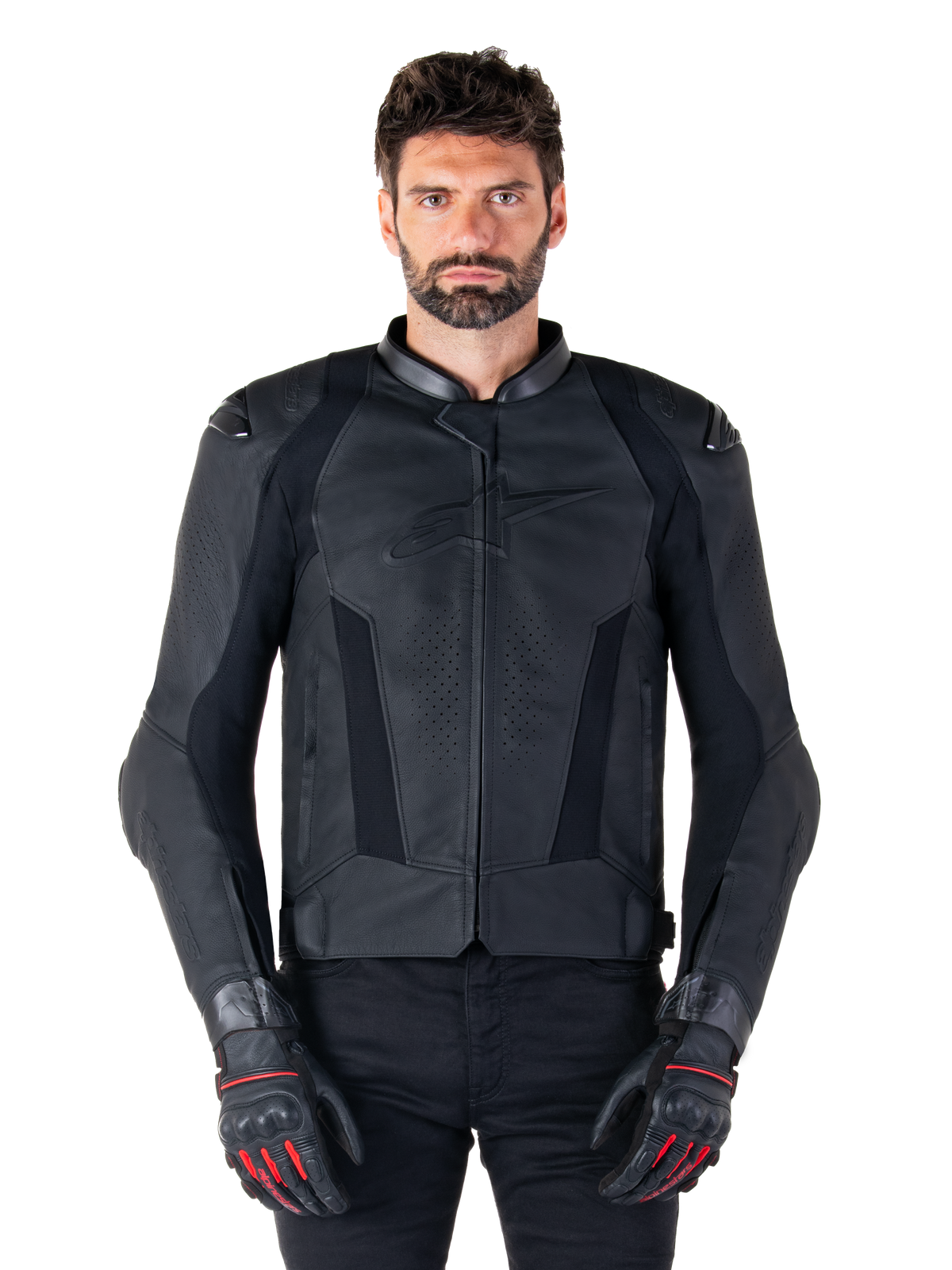 Alpinestars Missile V3 Leather Jacket, czarna skórzana kurtka motocyklowa wyścigowa, prezentowana na modelu z dopasowanymi czarnymi rękawicami i spodniami, posiada perforowaną skórę dla wentylacji, zewnętrzne slidery ramion oraz smukły sportowy design