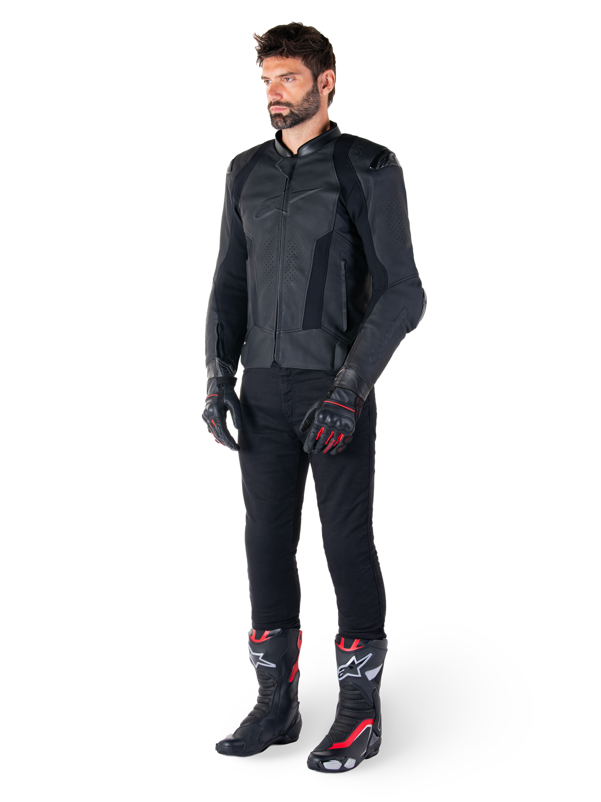 Alpinestars Missile V3 Leather Jacket, czarna kurtka skórzana, noszona przez motocyklistę w czarnych spodniach oraz czarno-czerwonych rękawicach i butach wyścigowych, z perforowanymi panelami skórzanymi i eleganckim monochromatycznym brandingiem, profesjonalna sportowa estetyka wyścigowa