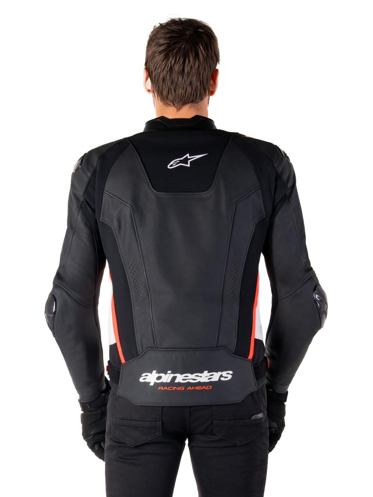 Alpinestars Missile V3 Leather Jacket, widok z tyłu, czarna skóra premium z czerwonymi fluorescencyjnymi i białymi akcentami, białe logo gwiazdy w górnej części pleców i branding Alpinestars na dole, czarne spodnie i rękawice