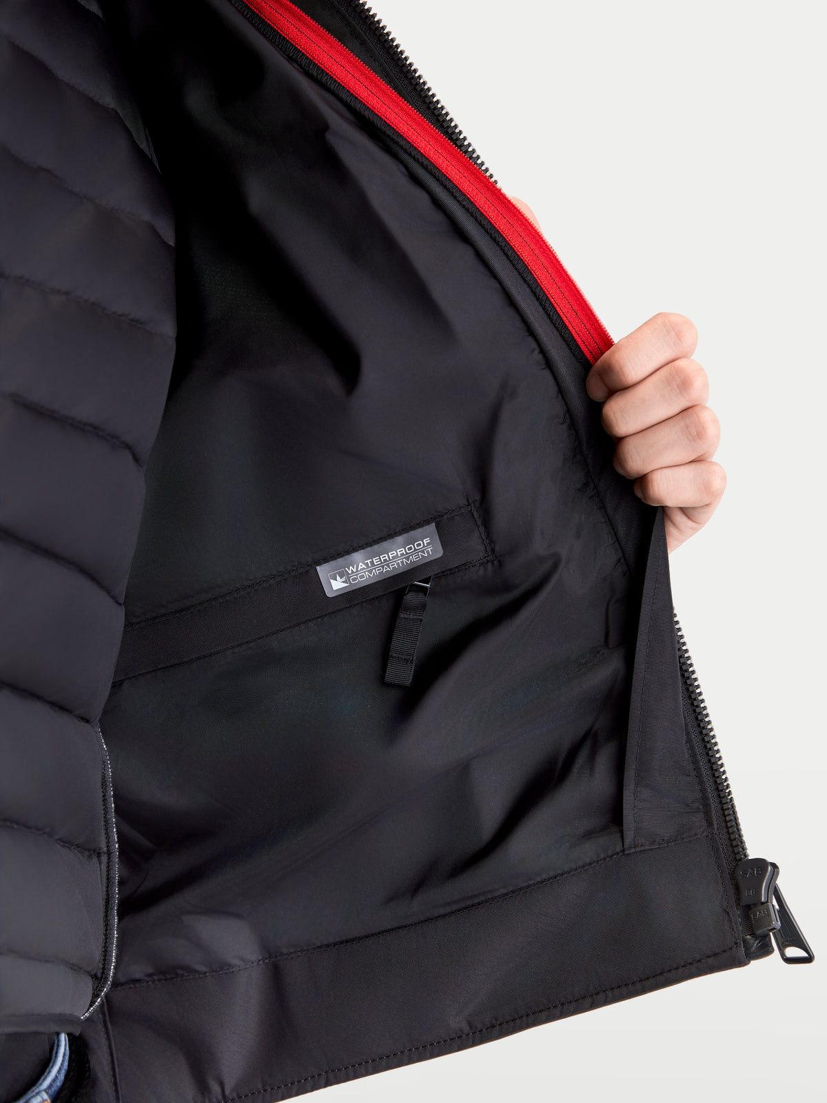 Alpinestars Revern Kurtka skórzana, męska urbanistyczna kurtka motocyklowa, detale wnętrza pokazujące odpinaną podpinkę kamizelki termicznej, wodoodporną kieszeń i czerwony akcent zamka błyskawicznego, czarna