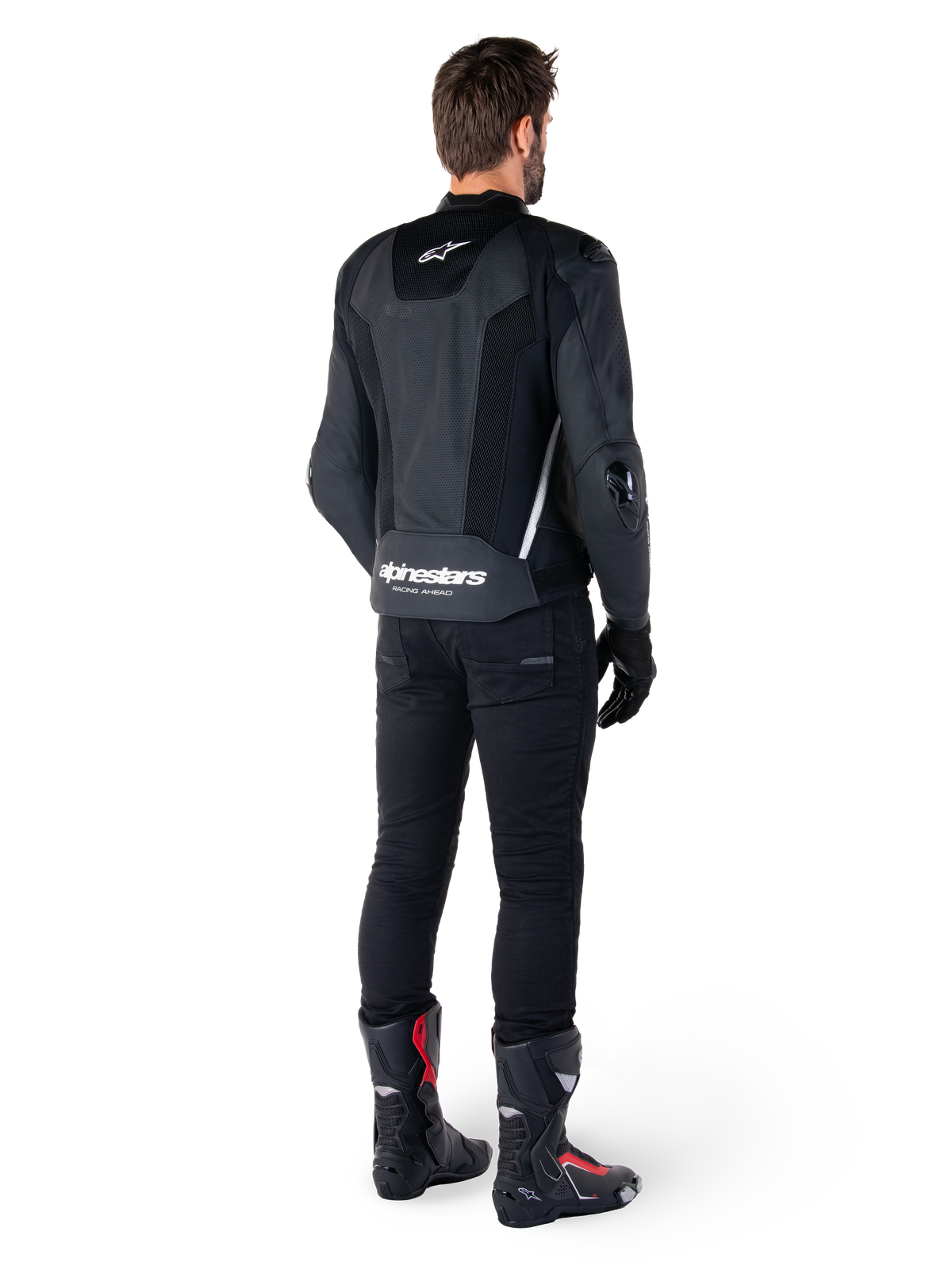 Alpinestars Missile V3 Airflow Leather Jacket, Black and White, rear view worn with black technical pants and racing boots, featuring perforated leather back panels and bold Alpinestars branding on the lower back.