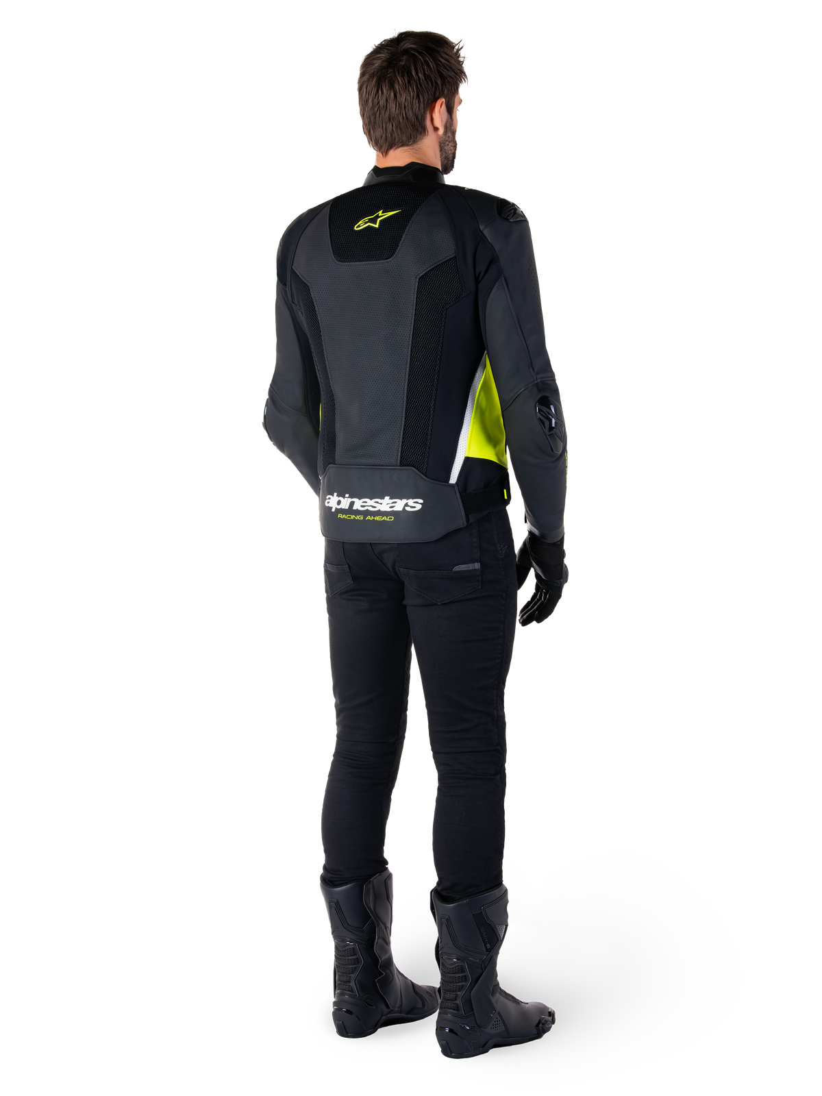 Skórzana kurtka Alpinestars Missile V3 Airflow, czarno-żółta fluo-biała, widok z tyłu na motocykliście, perforowane skórzane panele na plecach, żółte logo Alpinestars, białe akcenty, czarne spodnie i buty motocyklowe