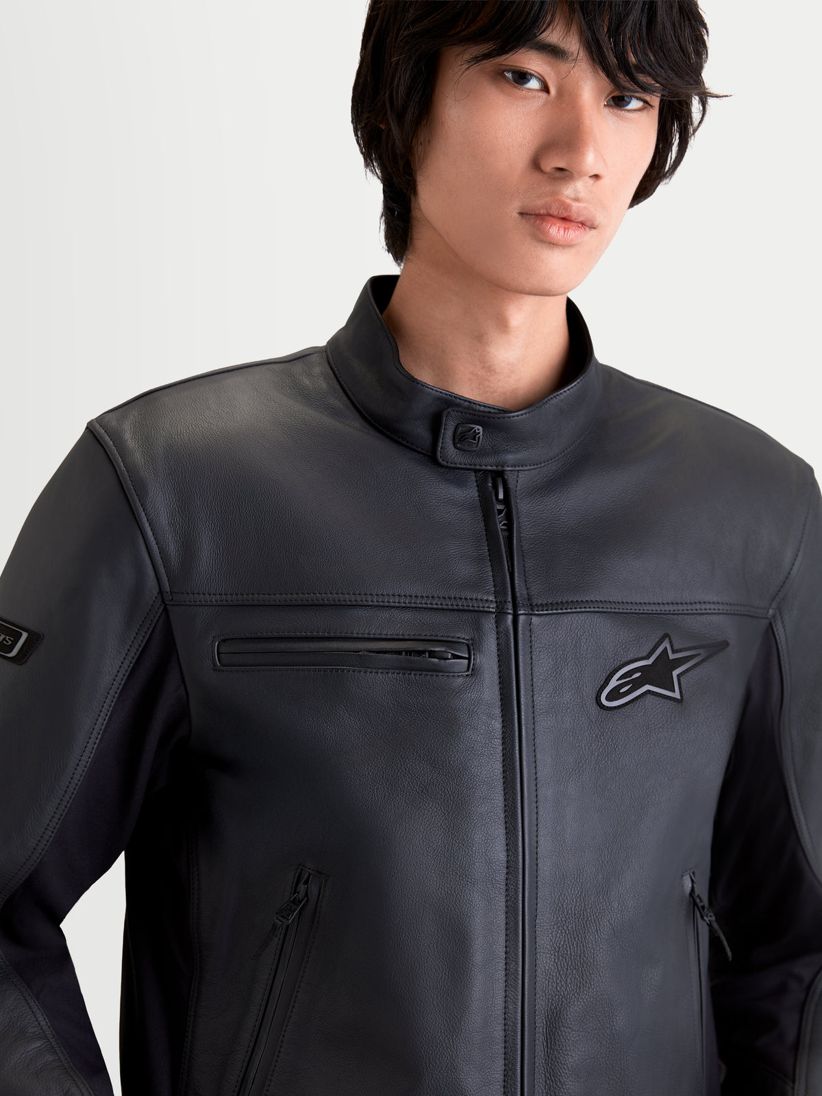 Alpinestars Maver X Kurtka skórzana męska urban contemporary, czarna, zbliżenie z przodu na model w skórzanej odzieży z kieszeniami na zamek i kołnierzem motocyklowym