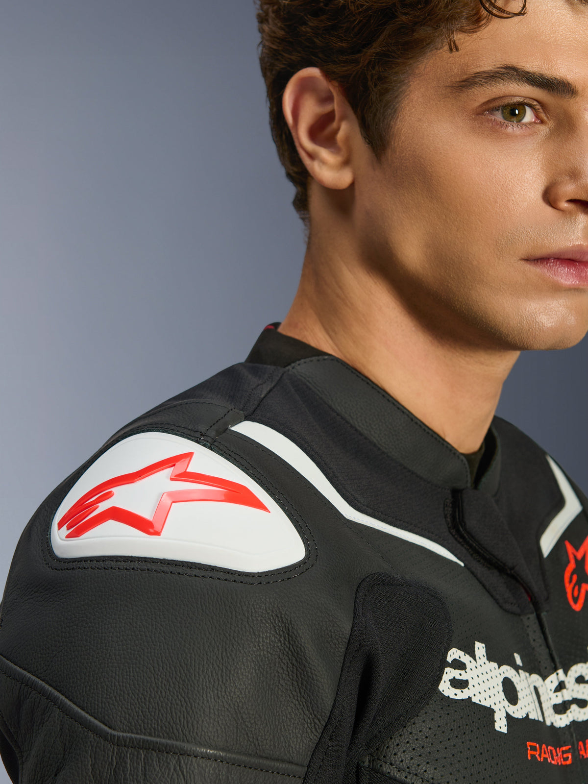 Skórzana kurtka Alpinestars GP Force V2 Air, czarno-biała, zbliżenie na modela w kurtce, biały slider ramion GP Lite Evo DFS z czerwonym logo i detale z perforowanej skóry