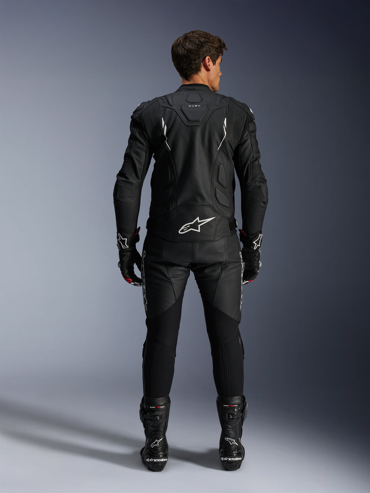 Kurtka Alpinestars Dusk i spodnie Missile V3, męski czarno-biały skórzany kombinezon wyścigowy, widok z tyłu.
