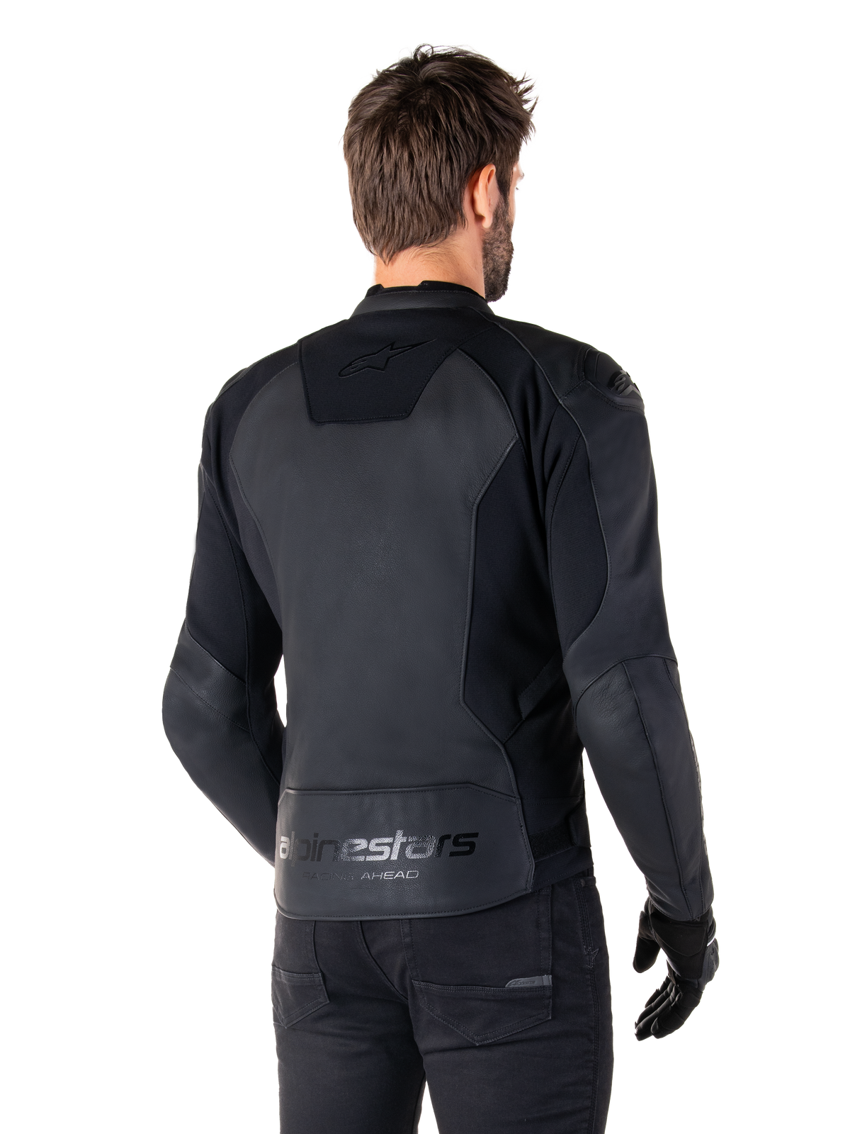 Alpinestars Faster V3 Leather Jacket, Black Black, widok z tyłu modelu w sportowej kurtce motocyklowej, z logo „alpinestars” i napisem „RACING AHEAD” na dole pleców, skóra premium z matowymi panelami, nowoczesna sportowa sylwetka do jazdy motocyklem