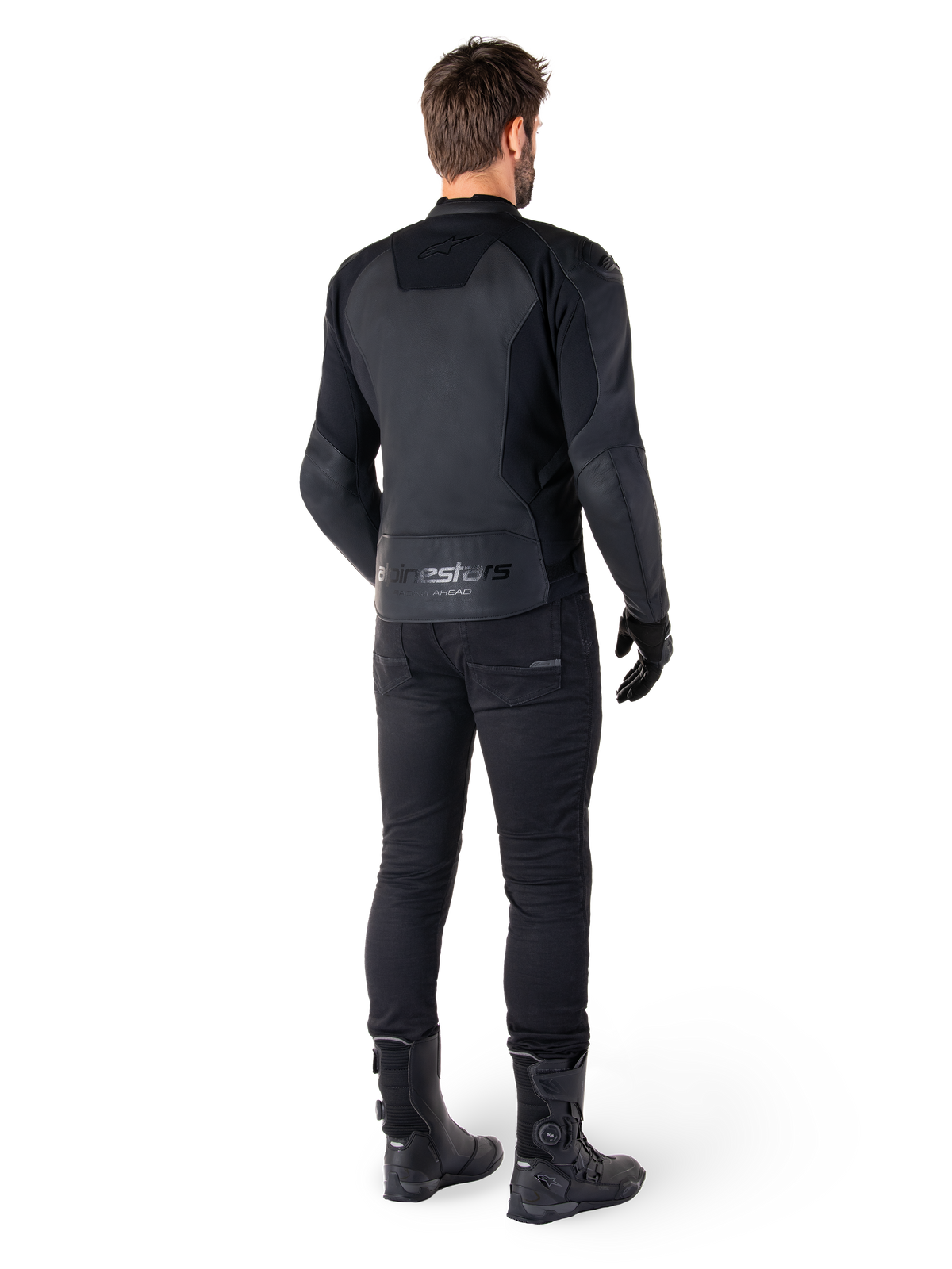 Skórzana kurtka Alpinestars Faster V3, Black Black, widok z tyłu na motocykliście, z panelami ze skóry premium i wytłaczanym logo Alpinestars, zestawiona z czarnymi spodniami i butami motocyklowymi dla pełnego sportowego wyglądu.