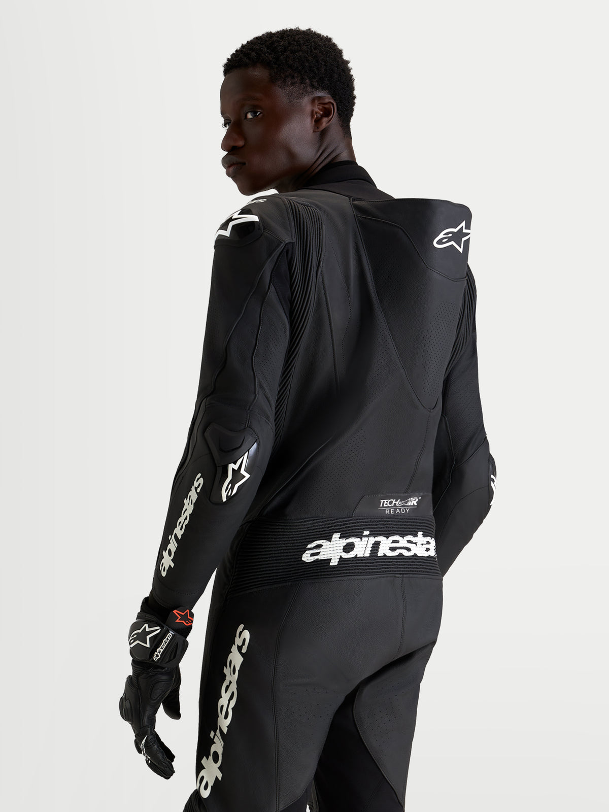 Alpinestars Missile V3 Leather Suit 1 Piece, men's black motorcycle racing leather suit, showing back view with aerodynamic speed hump, DFS armor, and white Alpinestars branding