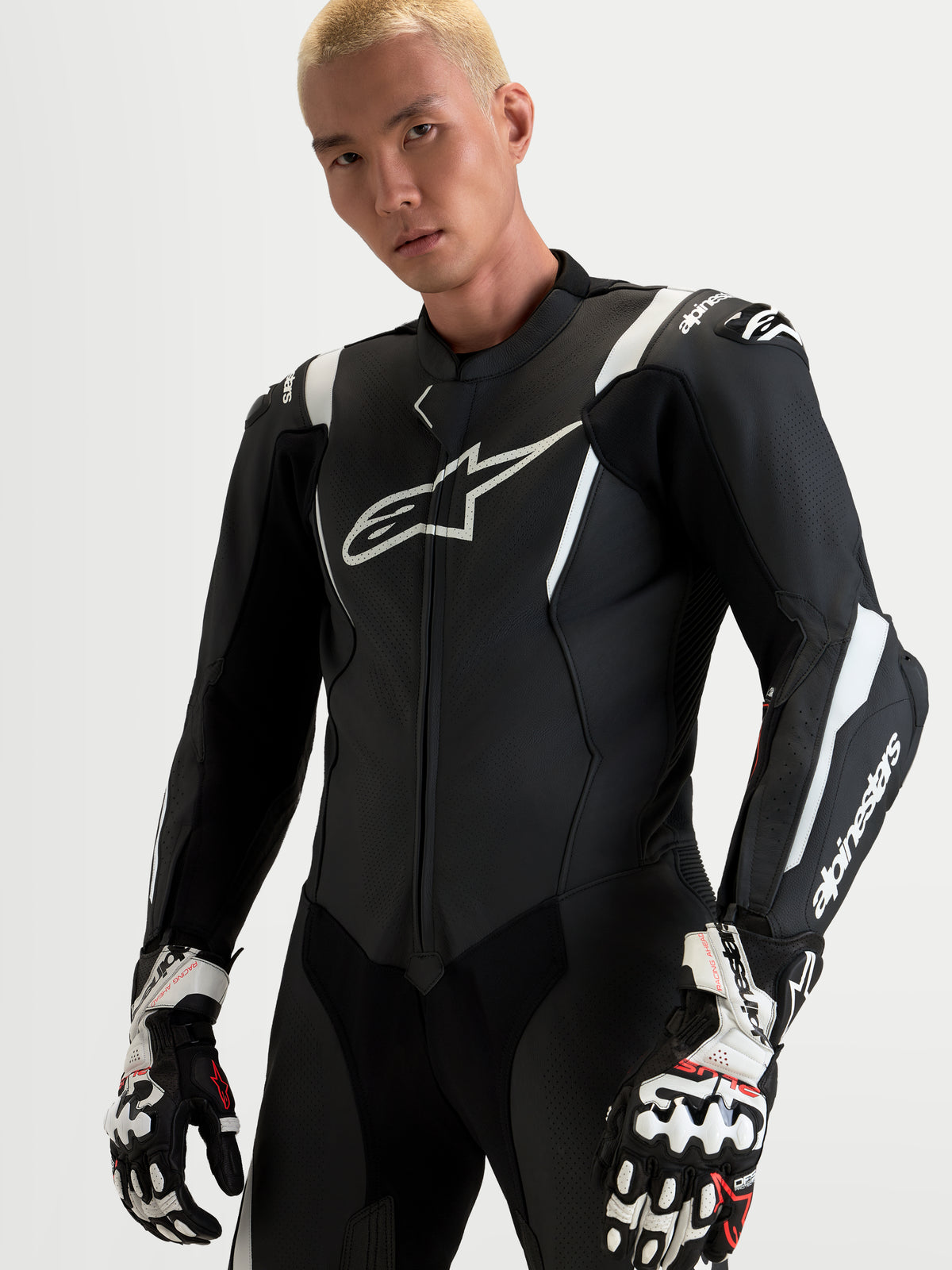 Alpinestars Missile V3 Leather Suit - 1 Pc, męski czarno-biały skórzany kombinezon wyścigowy z zintegrowaną ochroną DFS i panelami wentylowanymi, prezentowany na modelu