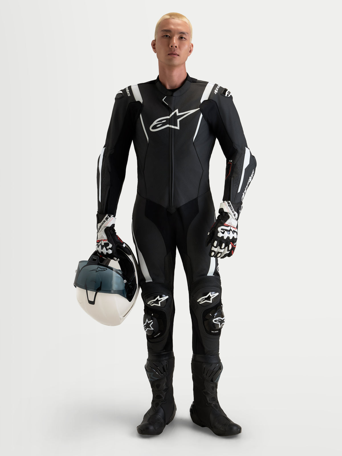 Alpinestars Missile V3 Leather Suit 1 Piece, męski czarno-biały skórzany kombinezon wyścigowy z certyfikatem AAA, zintegrowane ochraniacze ramion, łokci i kolan, model trzyma pasujący biały kask