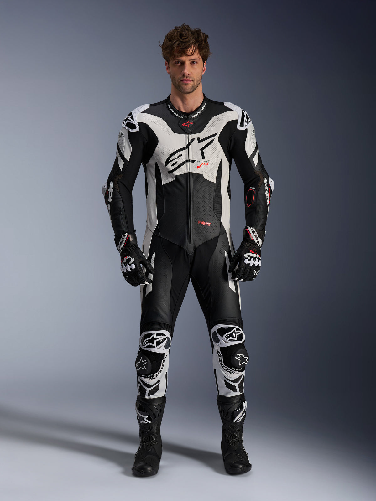 Alpinestars GP Plus V4 Sprint, męski jednoczęściowy skórzany kombinezon wyścigowy, czarno-biały z czerwonymi detalami fluo.