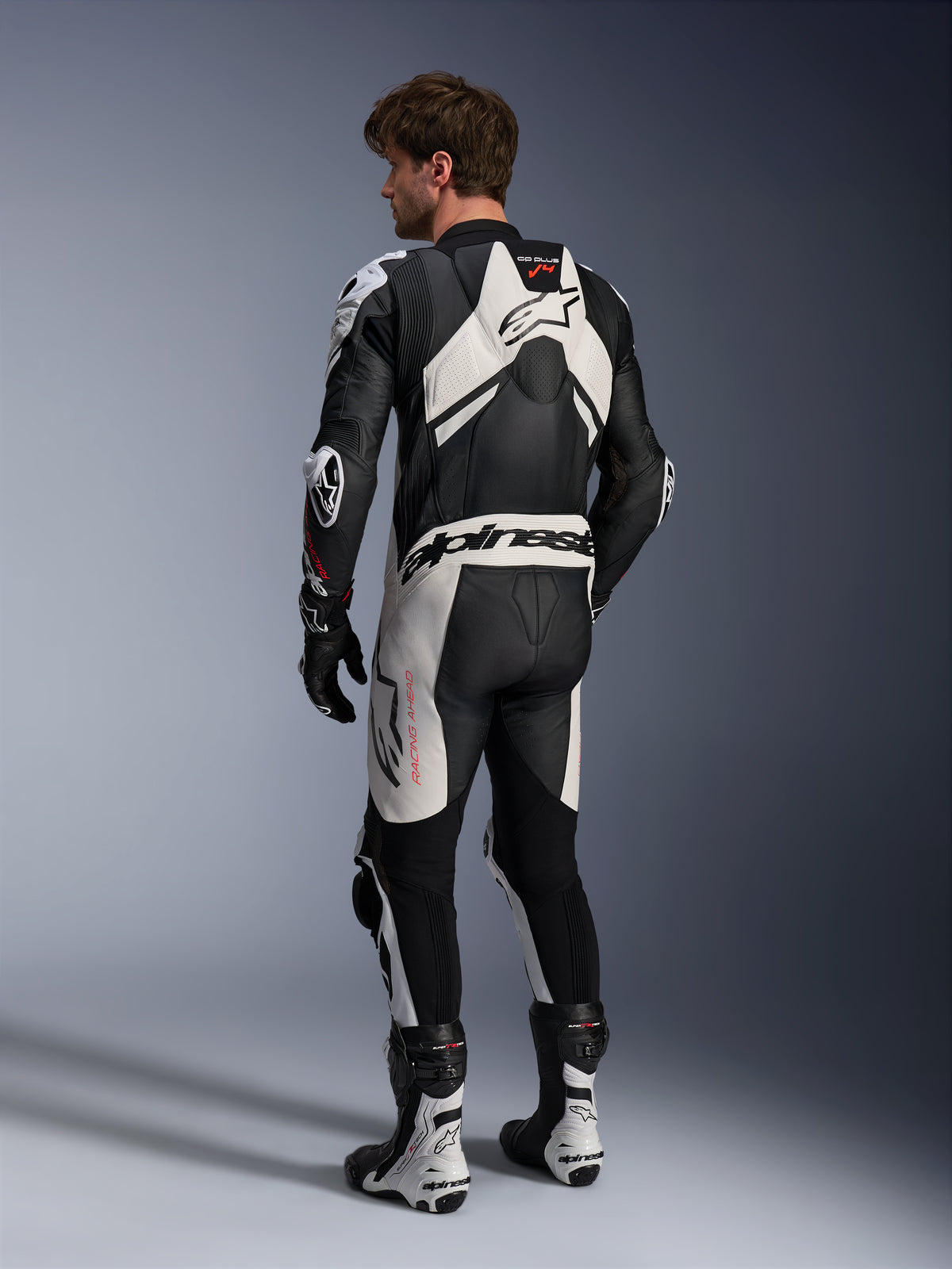 Alpinestars GP Plus V4 Sprint 1PC, męski skórzany kombinezon wyścigowy, czarno-biały, widok z tyłu z garbem aerodynamicznym.