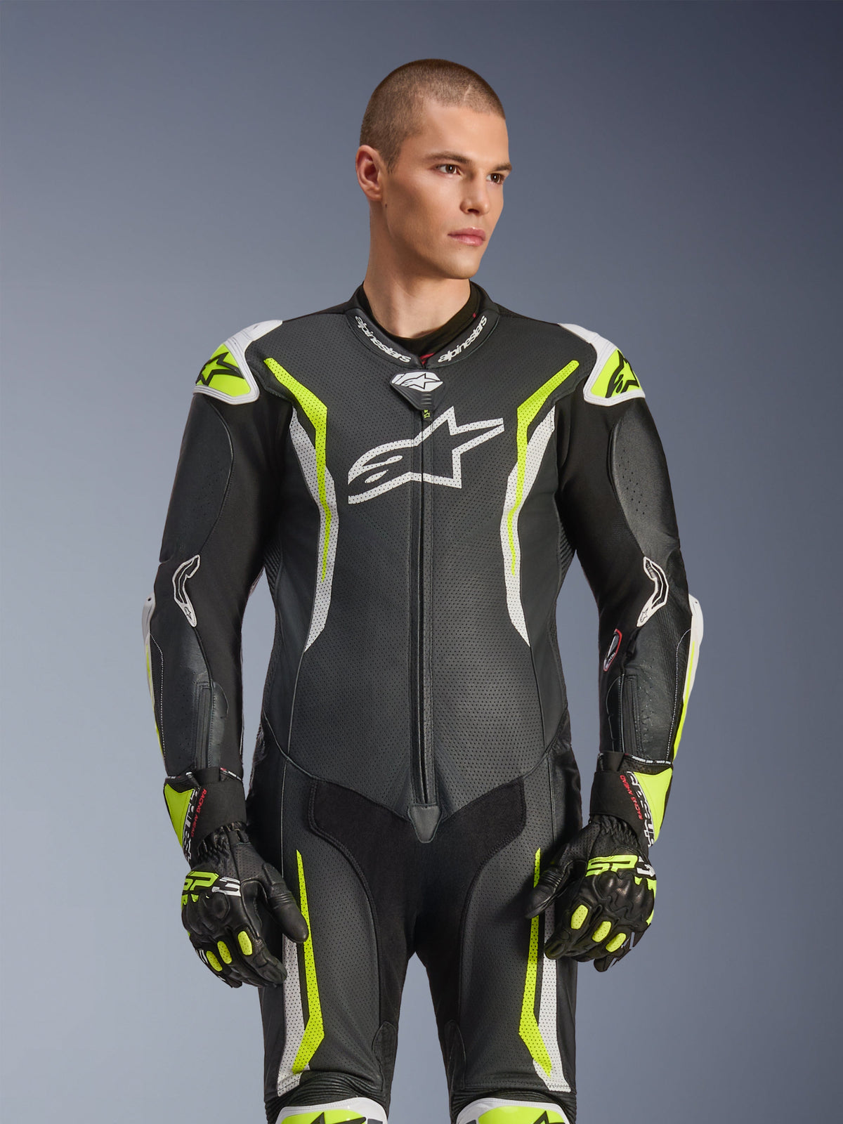 Alpinestars GP Tech V5 One Piece Leather Suit, czarny, biały i żółty fluo, profesjonalny sprzęt wyścigowy, perforowana skóra z dużym białym logo Astar na klatce piersiowej, fluorescencyjne żółte i białe akcenty, noszony z dopasowanymi rękawicami wyścigowymi