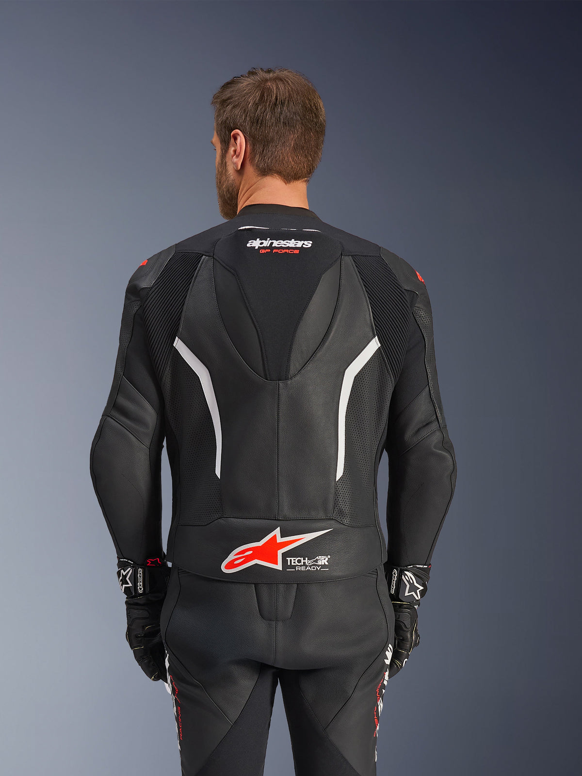 Alpinestars GP Force V2 Leather Suit - 2 Piece, Black White and Red Fluo, back view of leather jacket, featuring Tech-Air Ready logo, white accents, perforated leather panels, and accordion stretch for mobility.