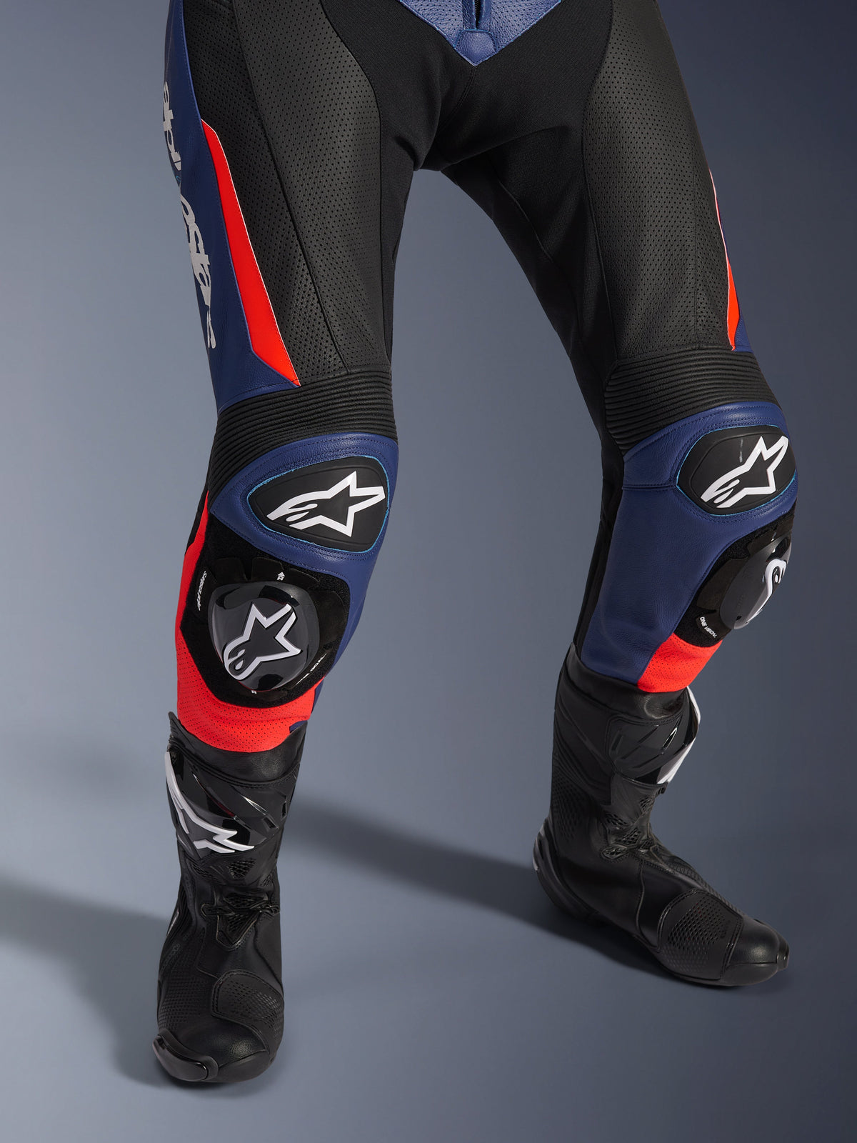 Alpinestars GP Force V2 Leather Suit - 2Piece, Motorcycle Racing Suit, Black Blue and Red Fluo, featuring perforated leather, accordion knee panels with protective sliders and Alpinestars logo branding, paired with black racing boots
