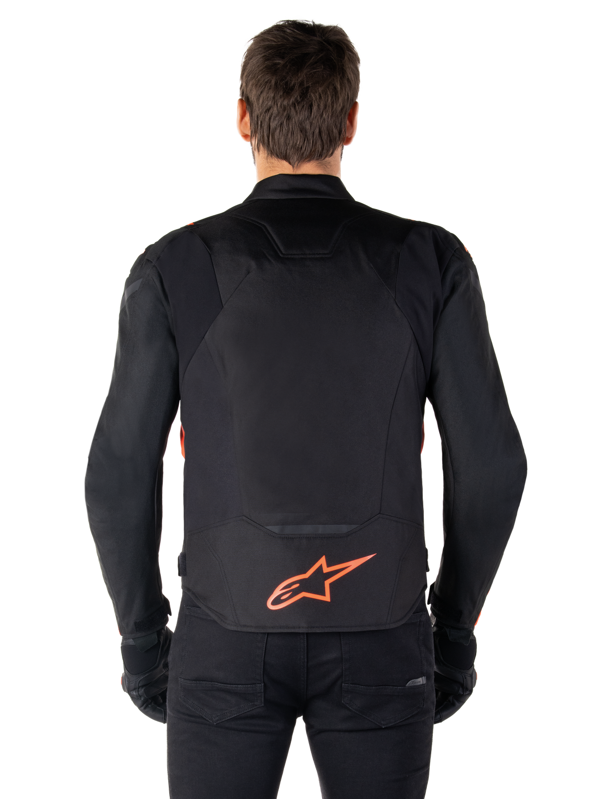 Alpinestars T-Jaws V4 Waterproof Jacket, widok z tyłu, czarna z czerwonymi akcentami fluo, czerwone logo Alpinestars na dole pleców, techniczna konstrukcja tekstylna, sportowy zestaw z czarnymi spodniami i rękawicami