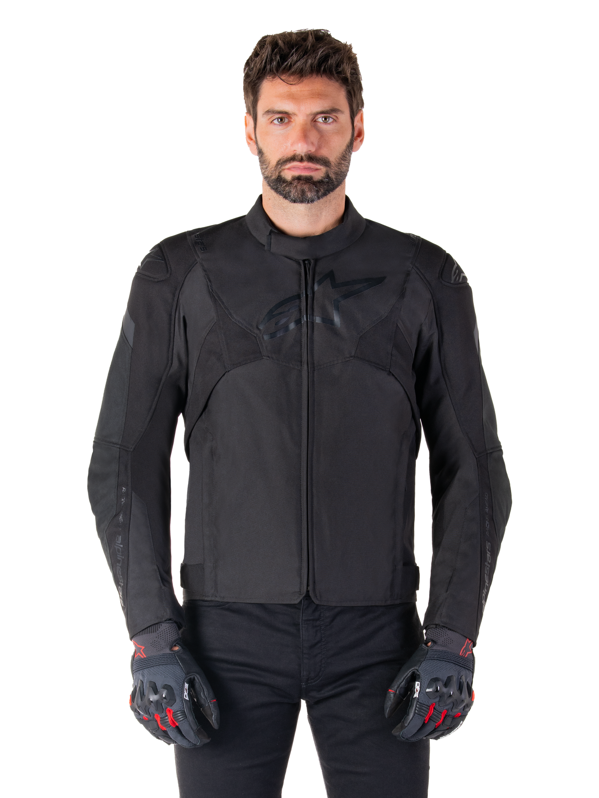 Kurtka motocyklowa Alpinestars T-Jaws V4 Waterproof, czarna sportowa kurtka motocyklowa, prezentowana na mężczyźnie w czarnych rękawicach z czerwonymi akcentami, wzmocnione barki i ramiona, elegancki design z subtelnym logo na klatce piersiowej, tekstylna odzież motocyklowa na każdą pogodę