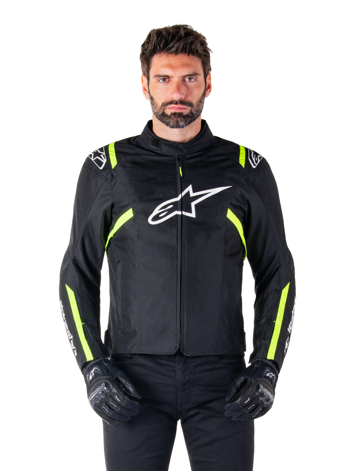 Wodoodporna kurtka motocyklowa Alpinestars T-SPS V2, czarna z białymi i fluorescencyjnymi żółtymi akcentami, noszona przez modela w czarnych rękawicach, z białym logo gwiazdy na klatce piersiowej oraz neonowymi żółtymi pasami na rękawach i ramionach, sportowa odzież tekstylna na każdą pogodę