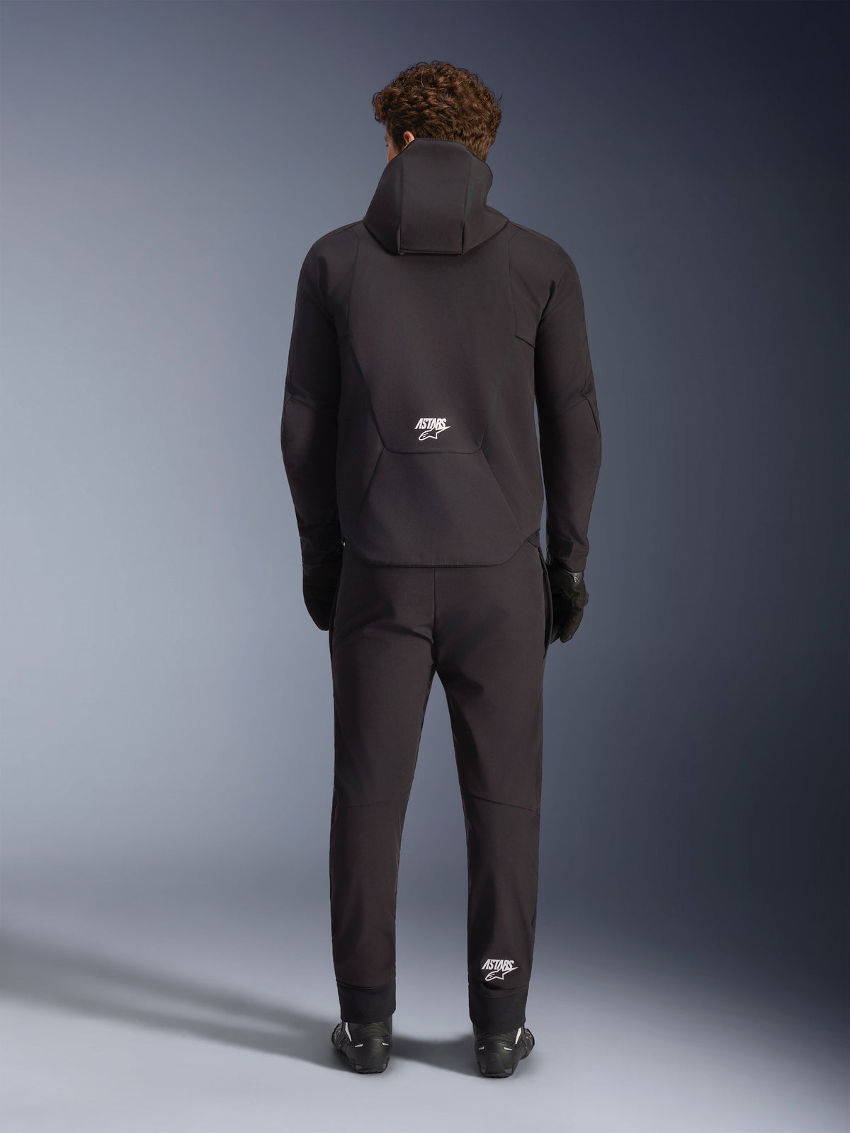 Alpinestars kurtka Aeroshell wodoodporna, męska czarna kurtka softshell z kapturem, widok od tyłu z białym logo ASTARS.