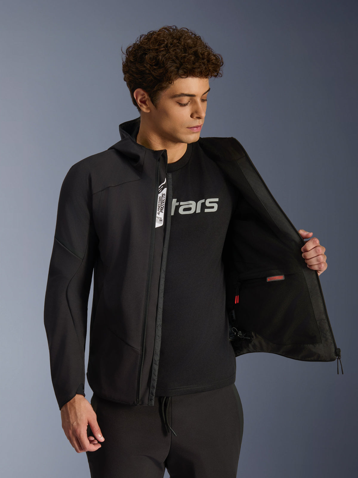 Alpinestars Aeroshell Waterproof Jacket, męska czarna kurtka motocyklowa softshell, rozpięta, ukazuje wewnętrzną kieszeń.