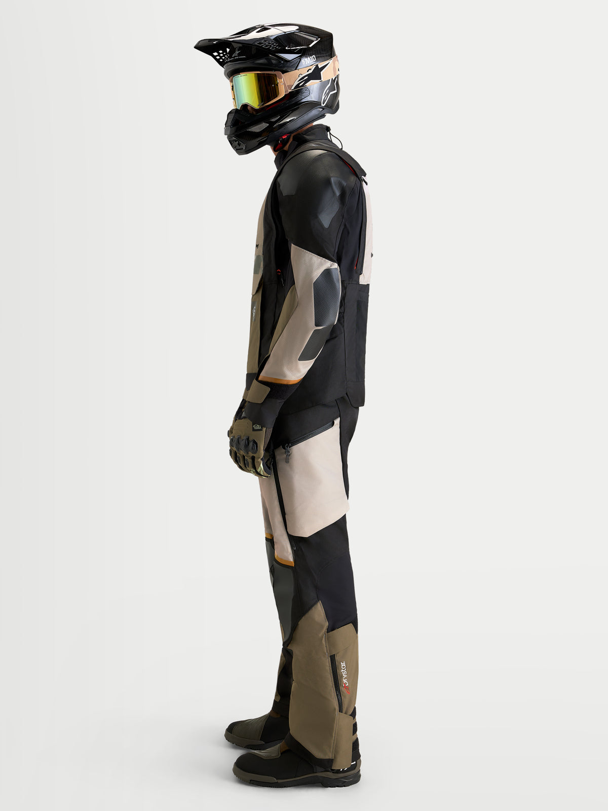 Alpinestars Harok V2 Drystar Gear Set, zestaw odzieży motocyklowej adventure, boczny widok profilowy modelu w pasującej kurtce i spodniach w kolorze czarnym i beżowym, wodoodporna odzież turystyczna