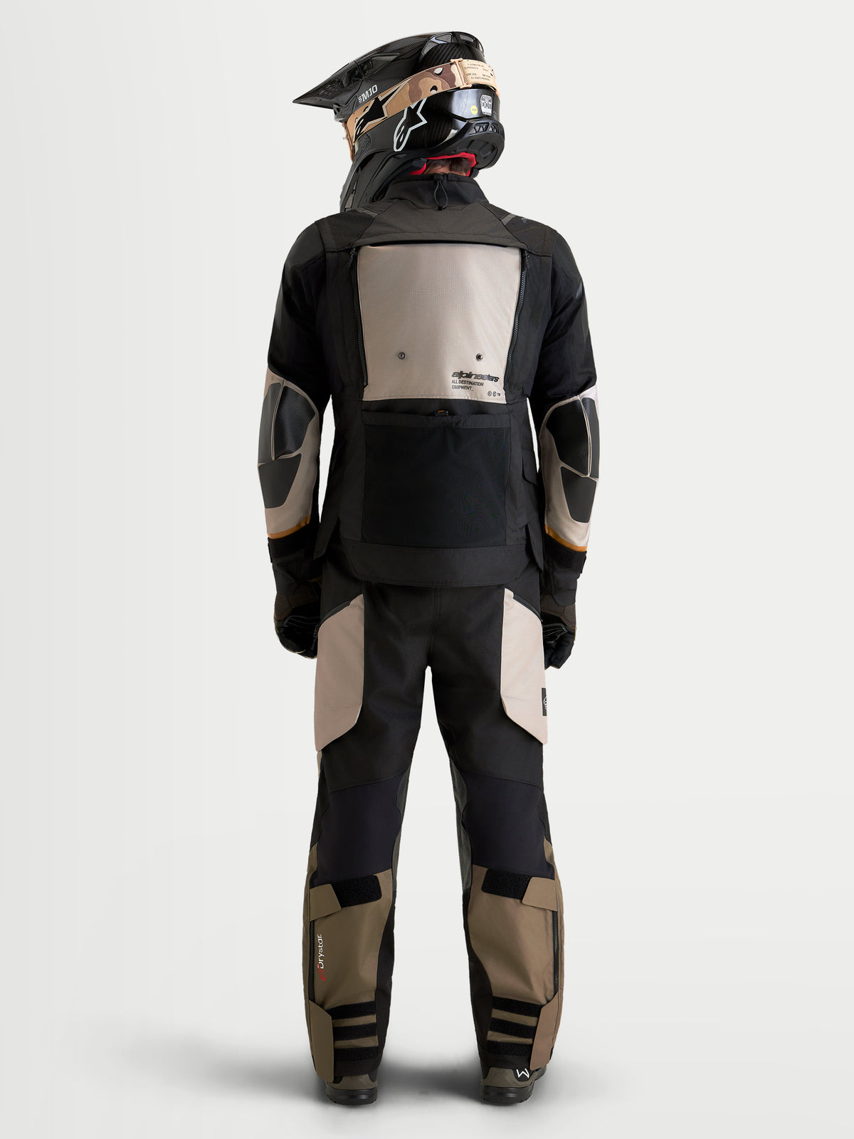 Alpinestars Harok V2 Drystar Gear Set, kurtka motocyklowa adventure i pasujące spodnie, widok z tyłu na model w kasku, czarne, beżowe i khaki, wodoodporna konstrukcja tekstylna z membraną Drystar