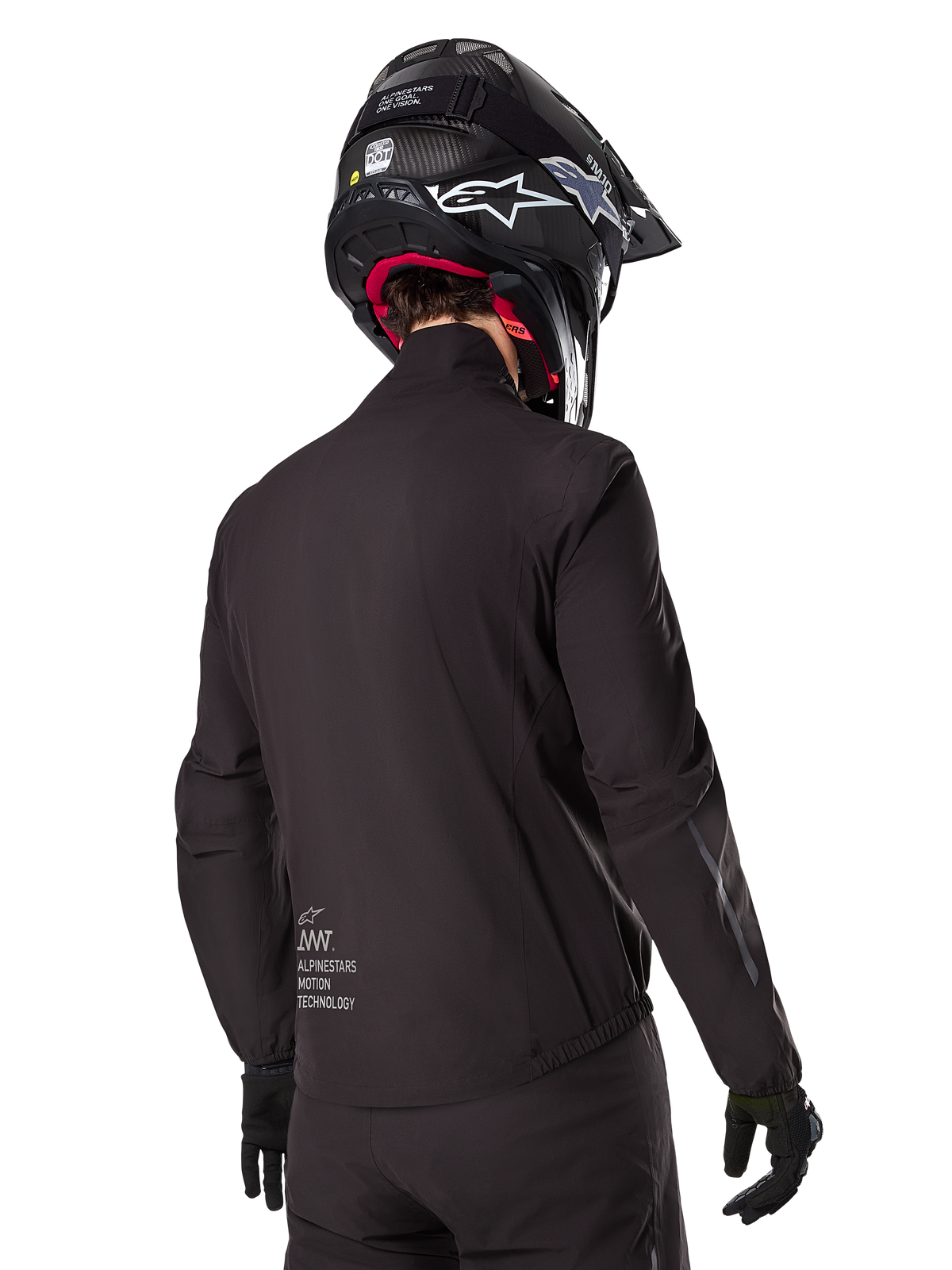 Alpinestars AMT-8 Stretch Drystar® XF Liner, czarna wodoodporna podszewka kurtki, widok z tyłu na motocyklistę w czarnym kasku i rękawicach, z logo Alpinestars Motion Technology na dole pleców, minimalistyczny i funkcjonalny design do jazdy adventure